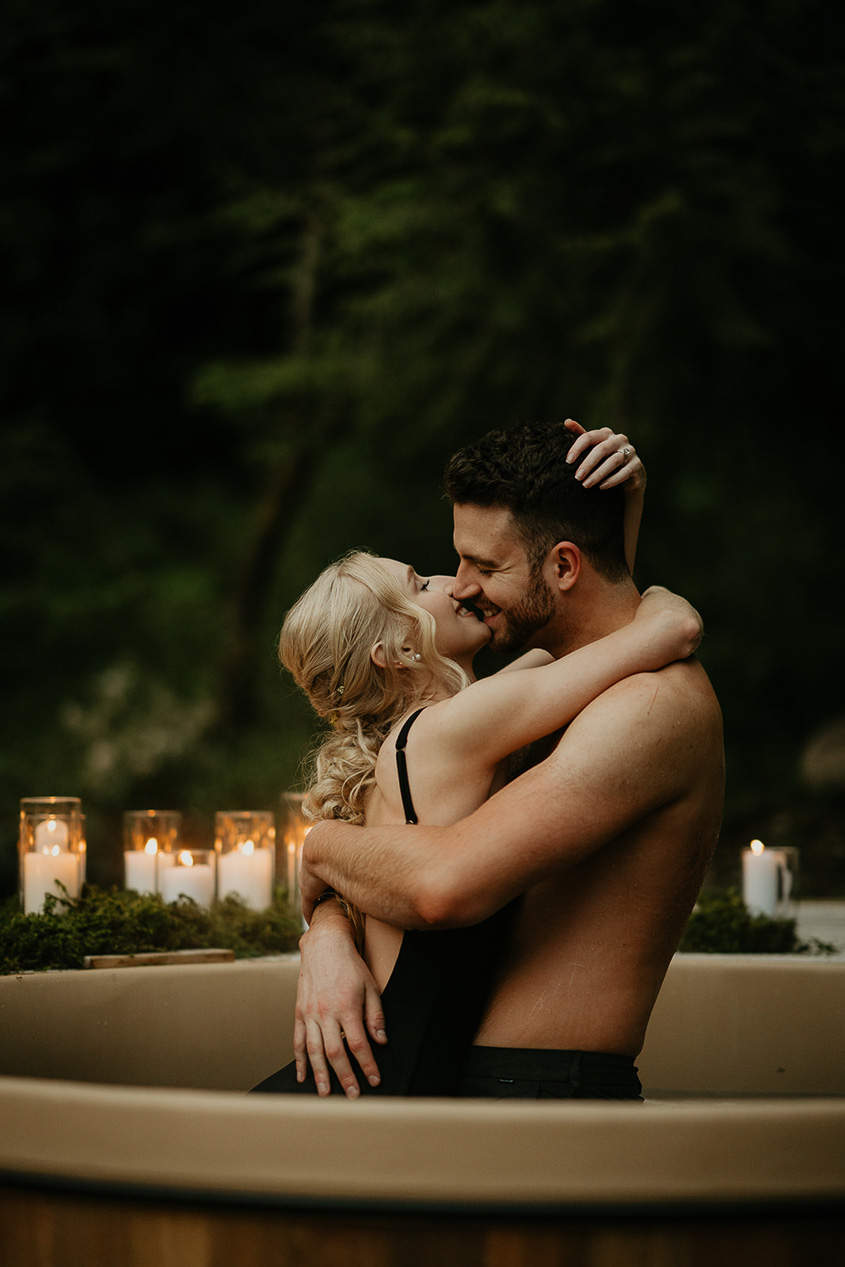 newlyweds kissing in a hot tub during their Highland Farms wedding venue.