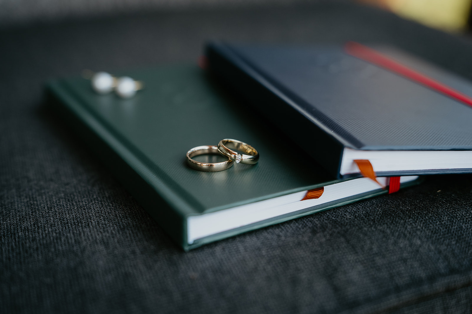 hand written vows and rings on a black table.