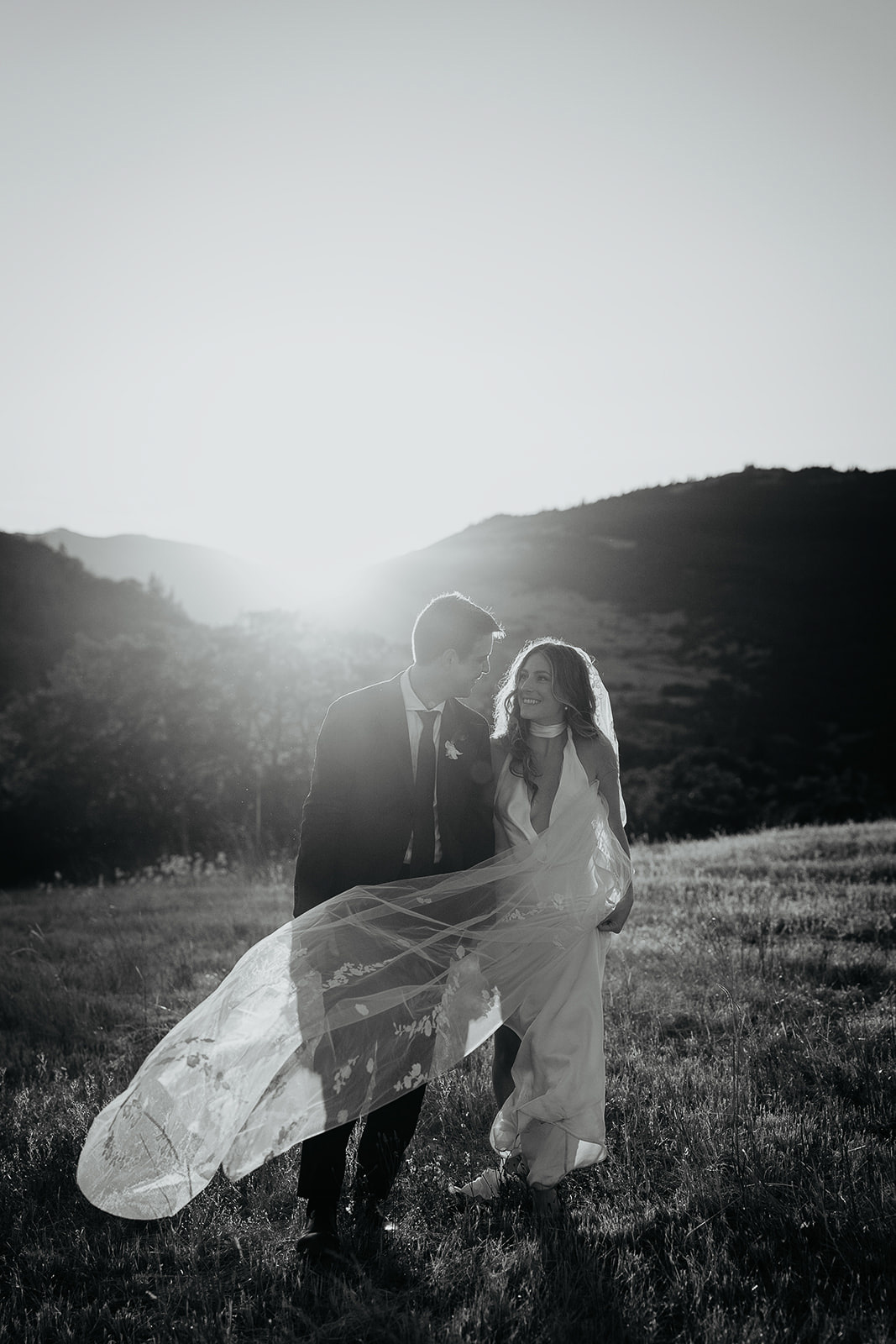 newlyweds walking in a field at sunset, which they included as part of their plan for their micro wedding.