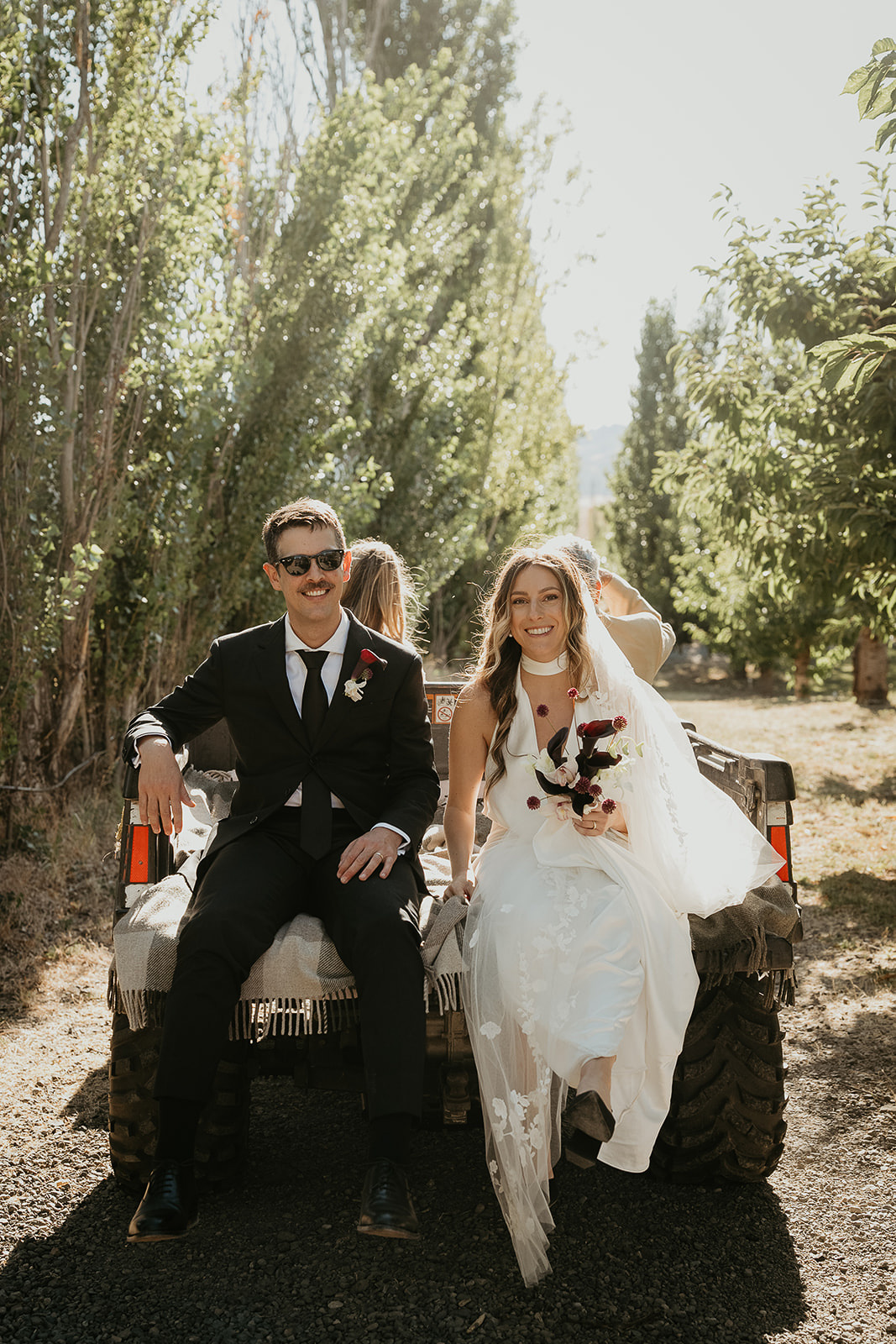 newlyweds riding in the back of a pick up truck