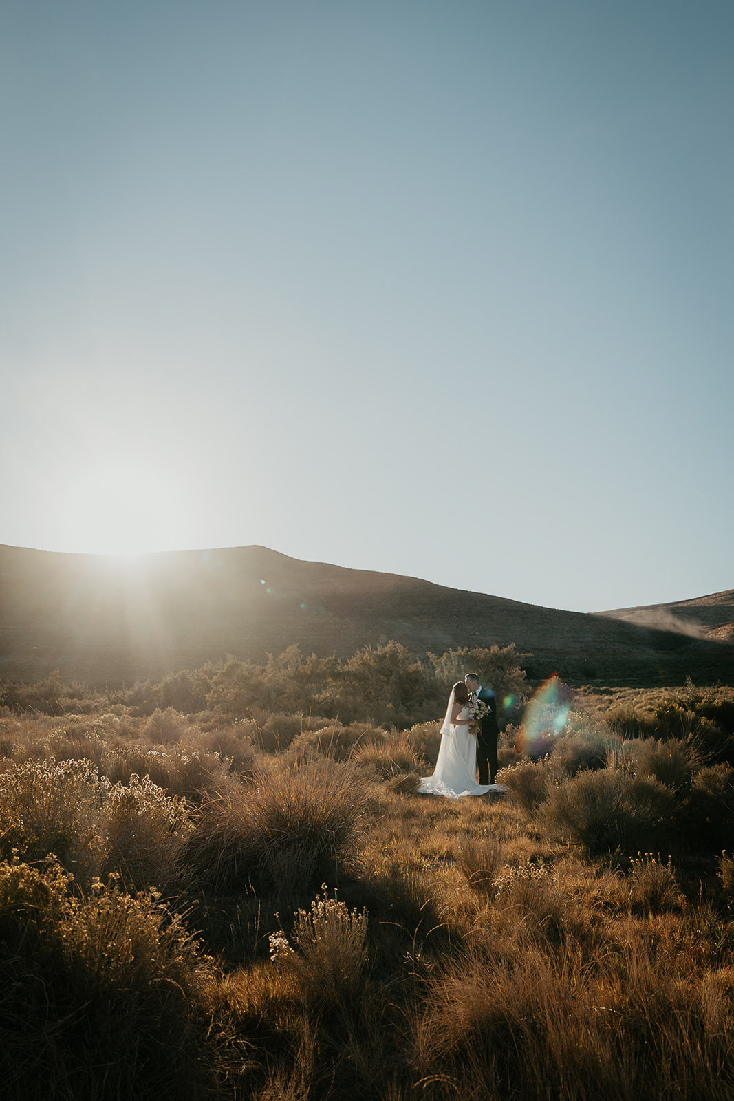 newlyweds hugging at sunset during their Alvord Desert, Oregon elopement.