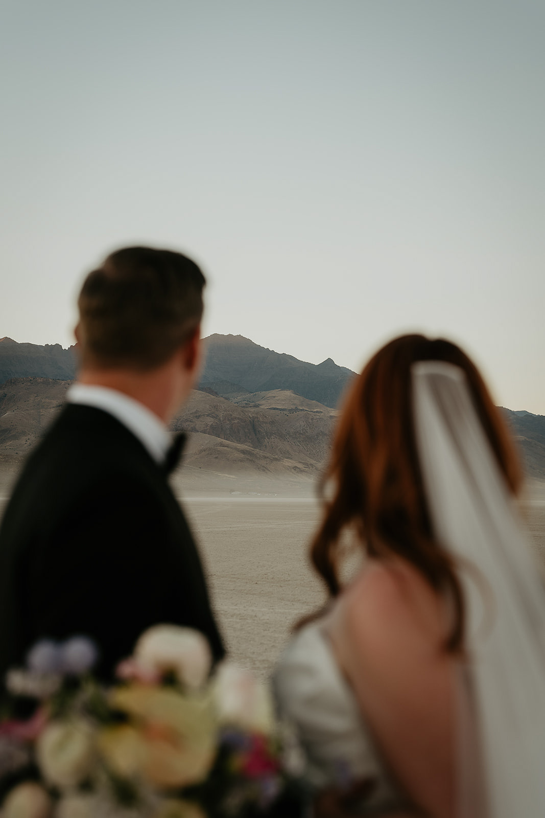 newlyweds looking off into the distance during their Alvord Desert, Oregon elopement.