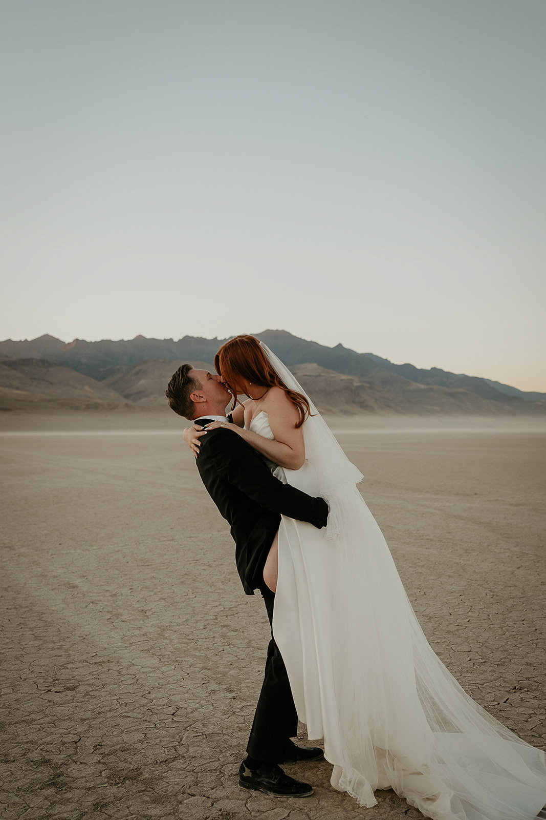 newlyweds kissing on a desert playa during their Alvord Desert, Oregon elopement.