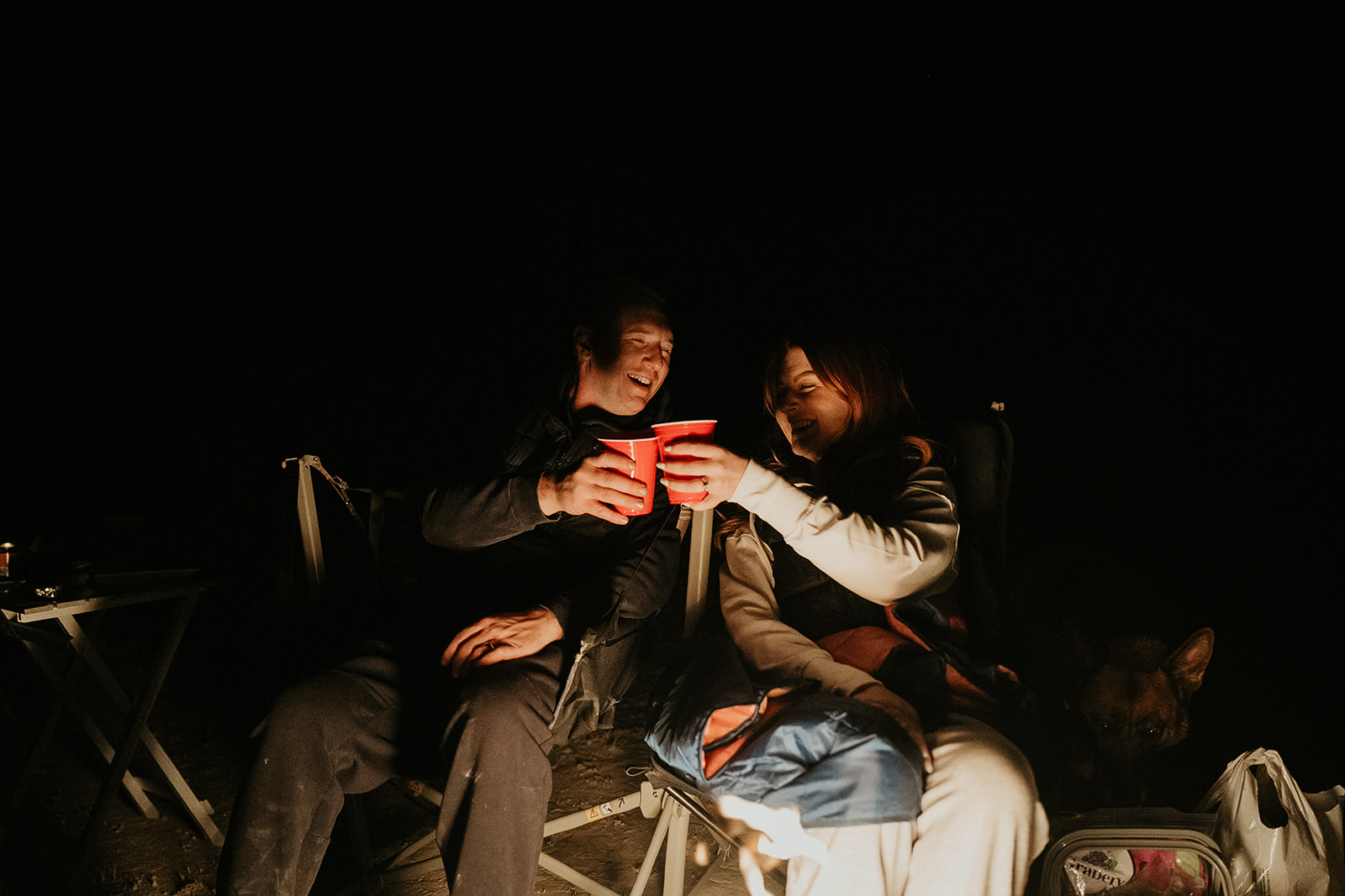 newlyweds sharing a drink around a fire during their Alvord Desert, Oregon elopement.
