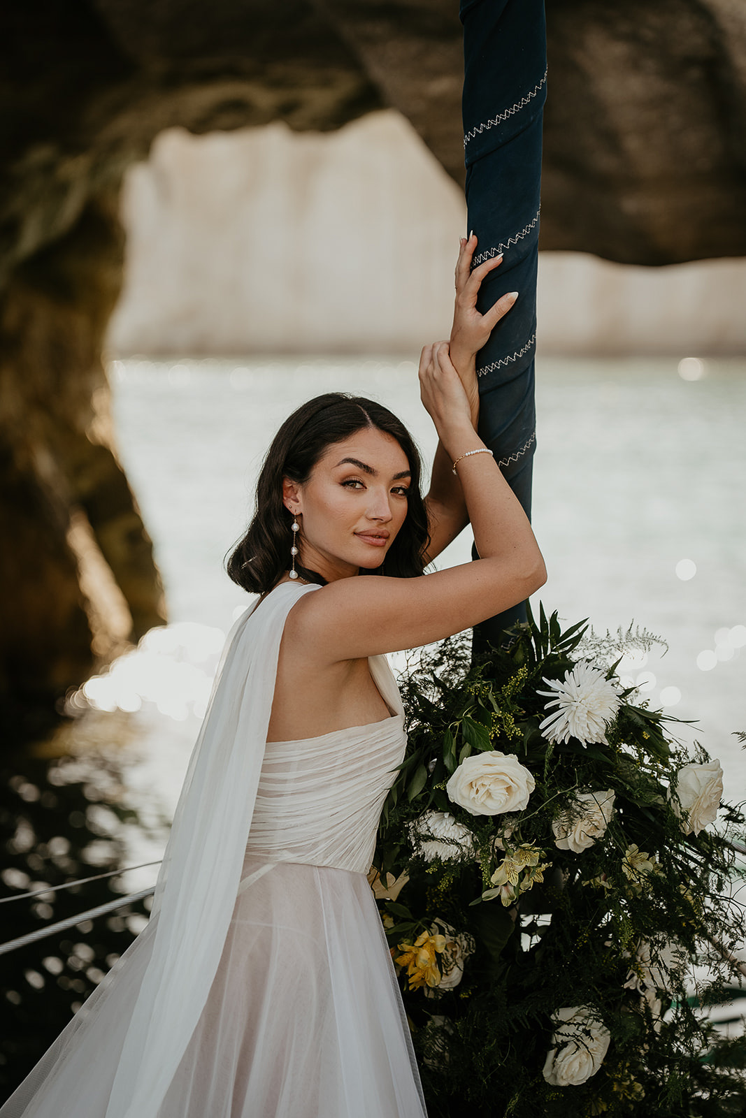 a bride and a bouquet of flowers on a sailboat.