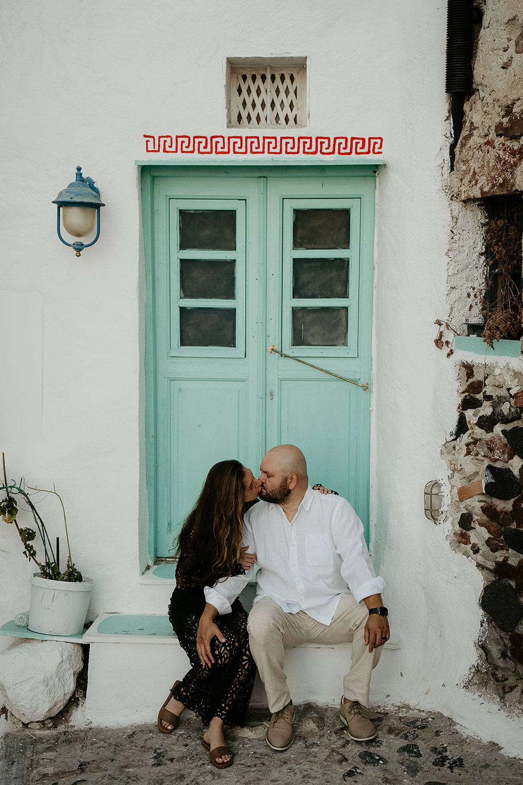a couple kissing in a doorway as they elope in Greece.