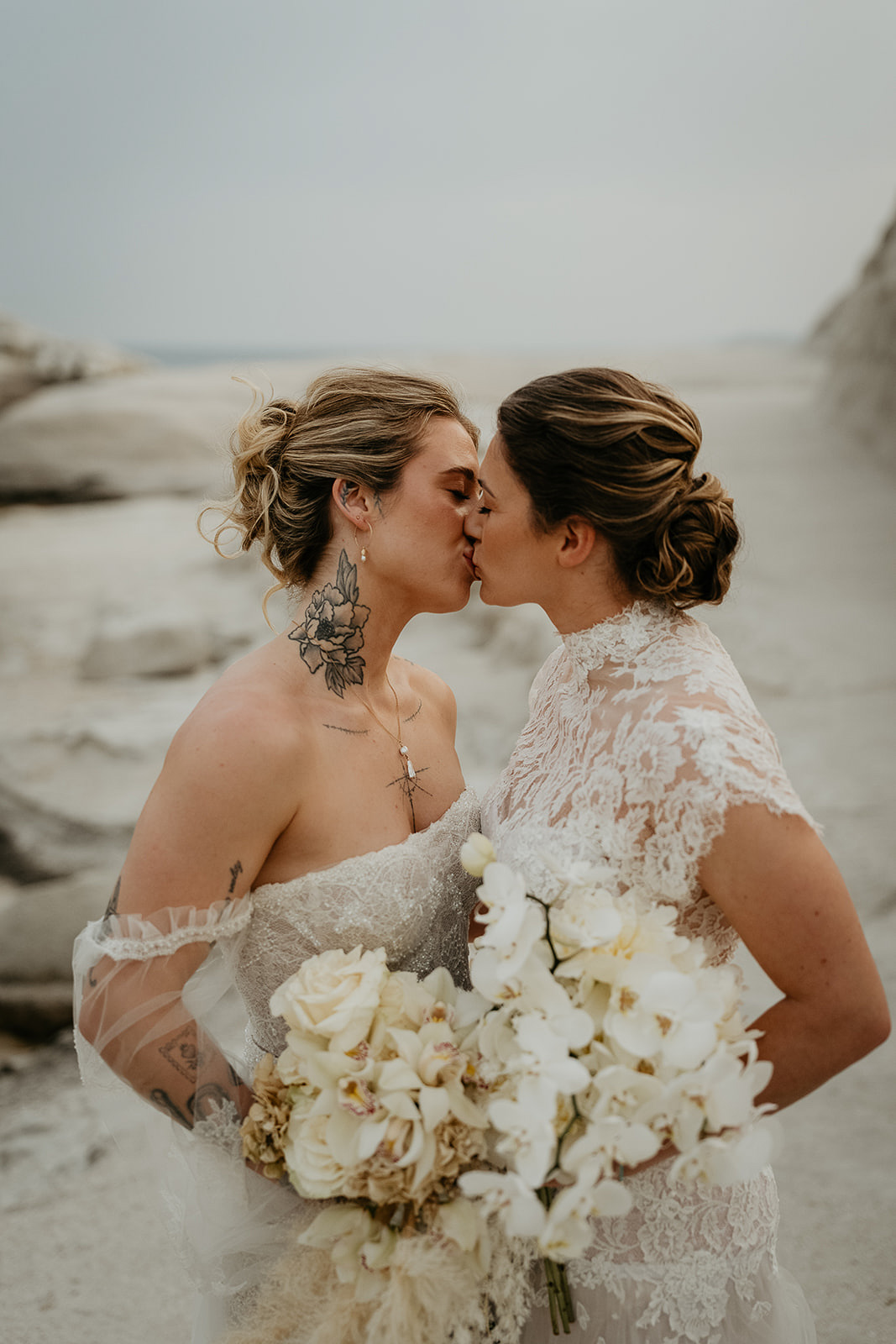 newlyweds kissing holding bouquets.