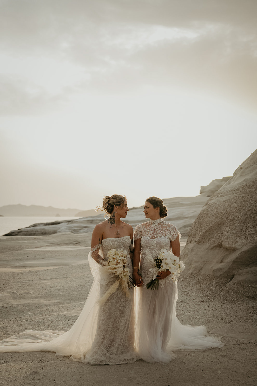 newlyweds standing side by side on the beach as they elope in Greece.
