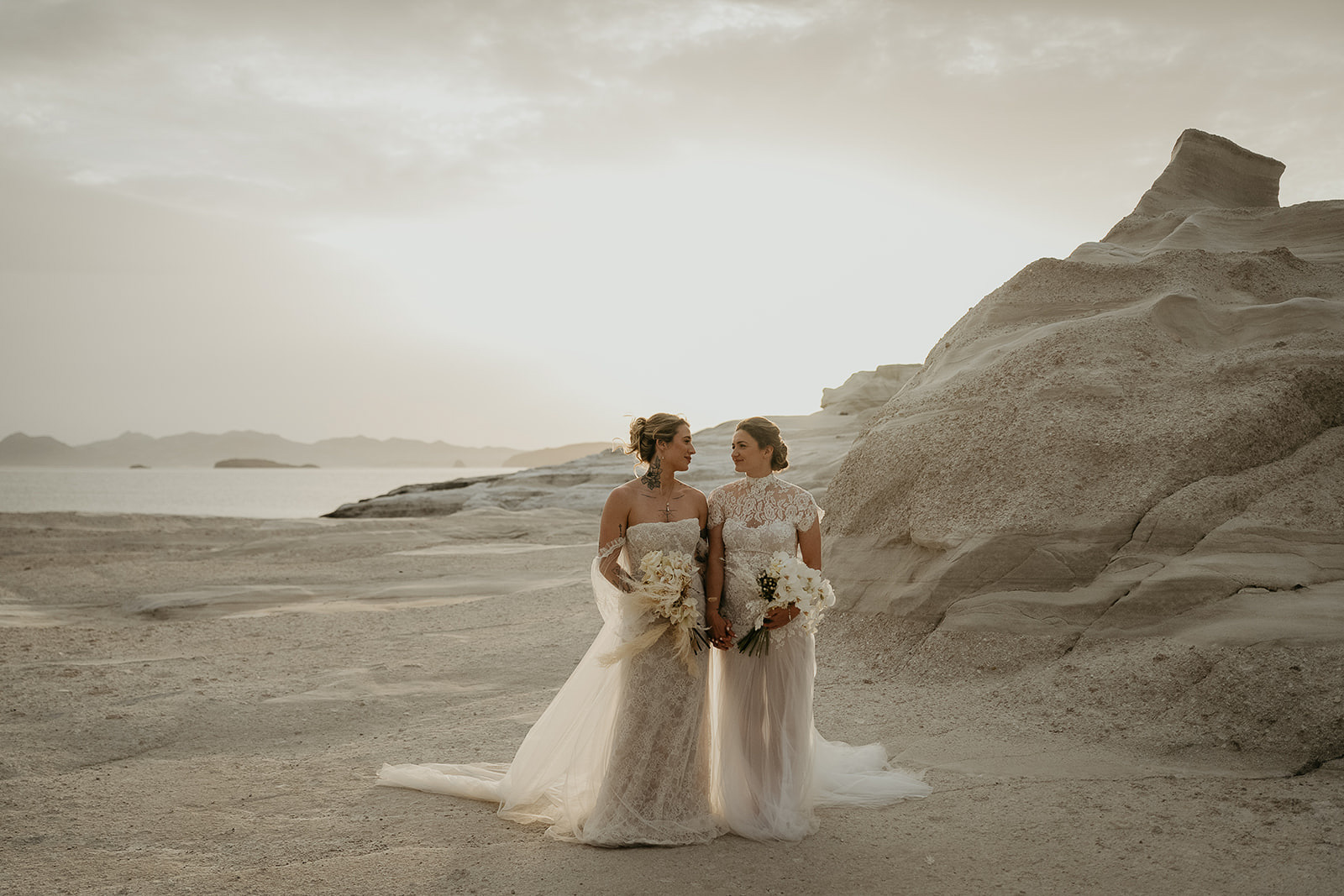 newlyweds holding hands on a beach as they elope in Greece.