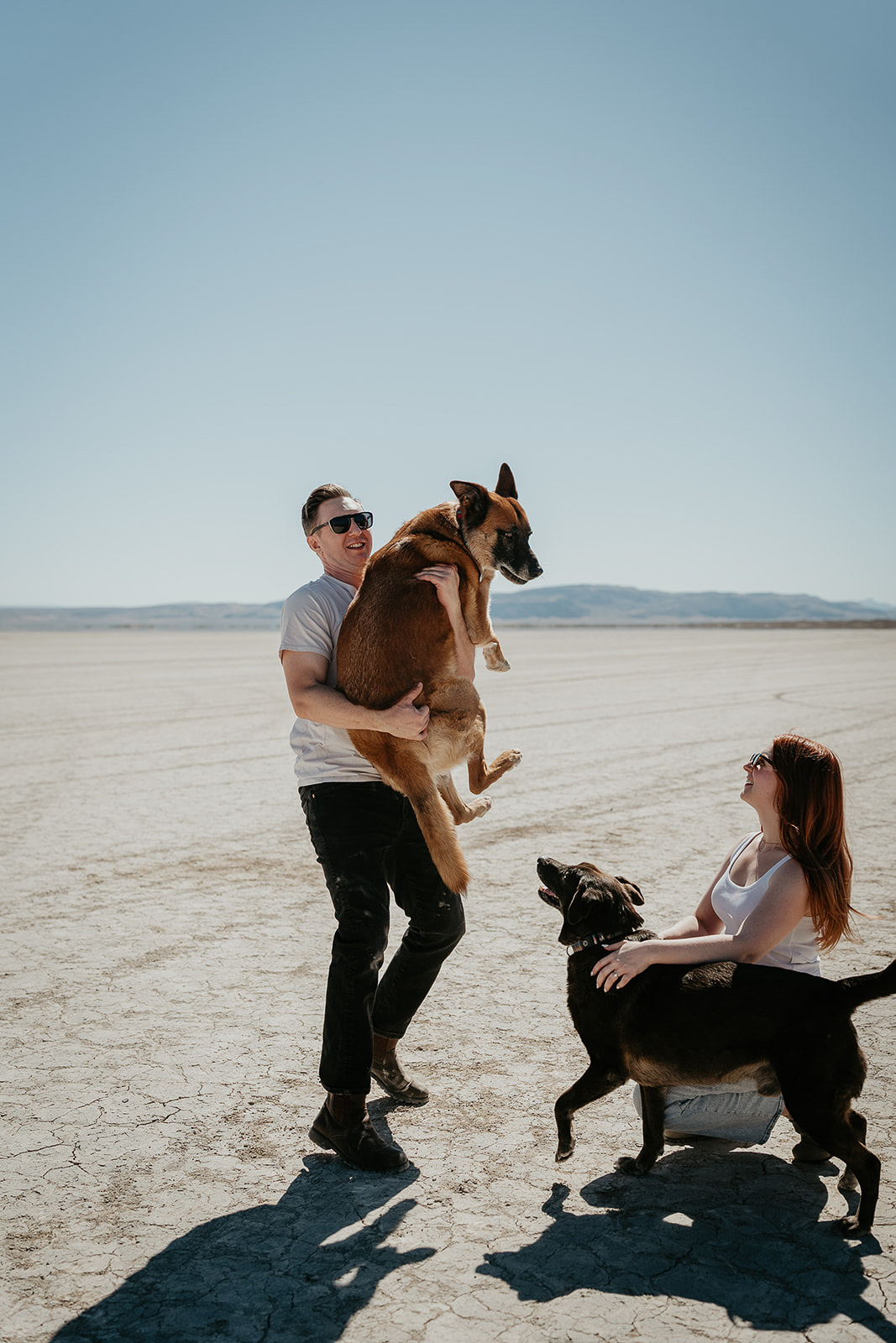 newlyweds carrying and petting their dogs during their Alvord Desert, Oregon elopement.