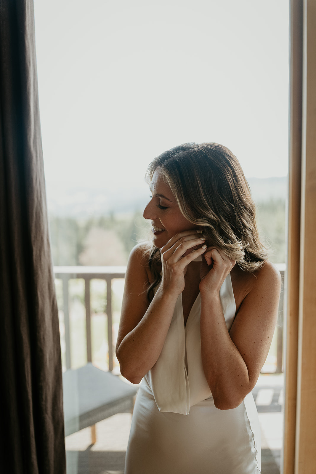 the bride putting on earrings before her waterfall elopement.