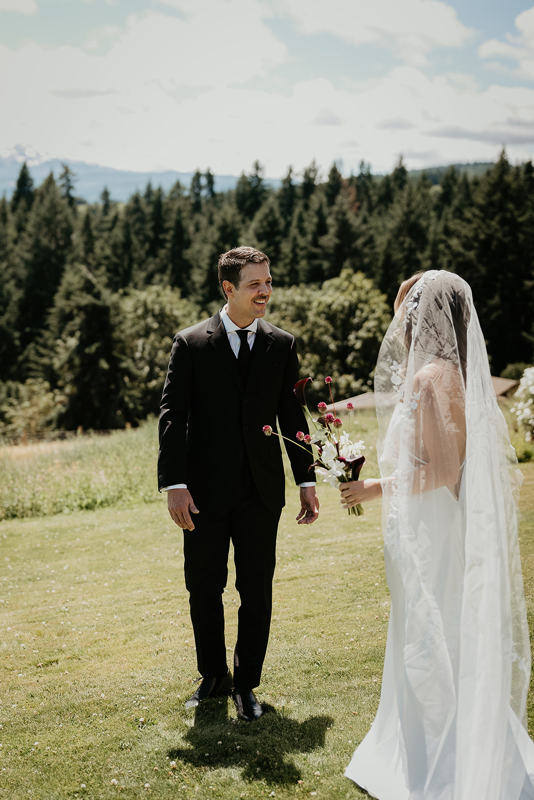 newlyweds enjoying a first look with the forest in the background