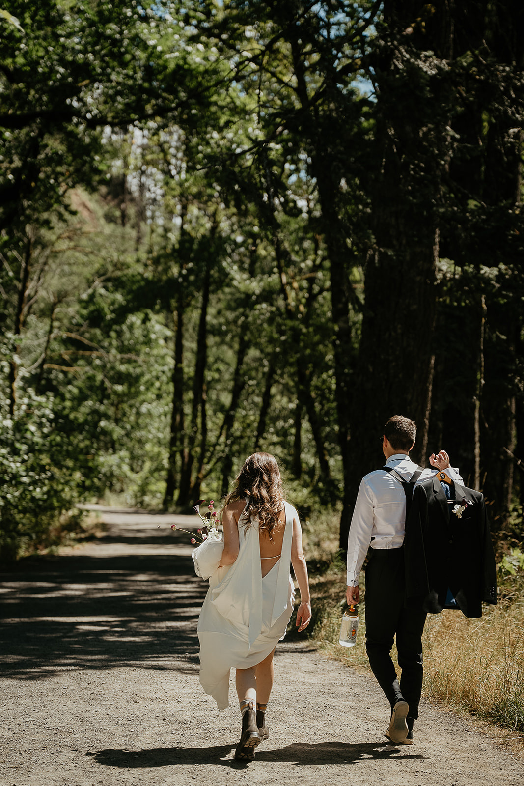 newlyweds walking along a trail on their way to their waterfall elopement.
