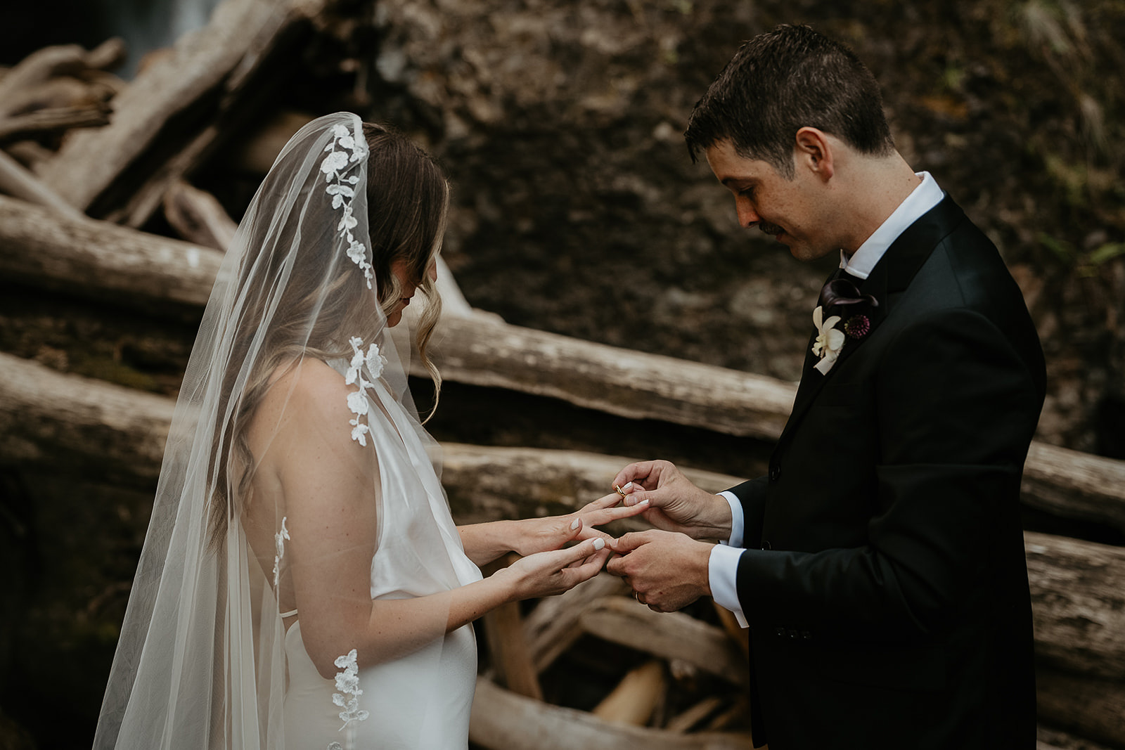 the newlyweds exchanging rings during their waterfall elopement.