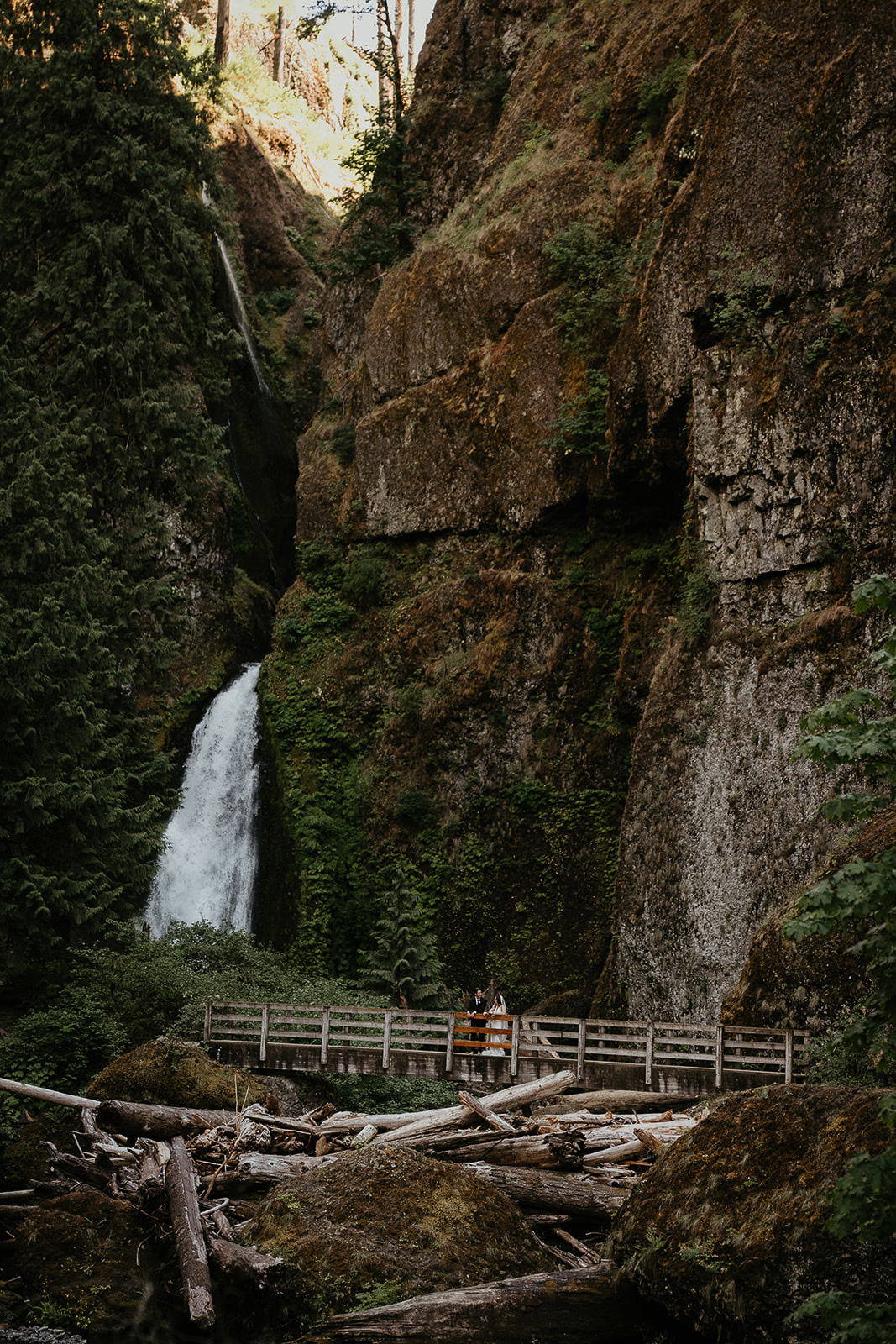 newlyweds on a bridge by a waterfall during their elopement.