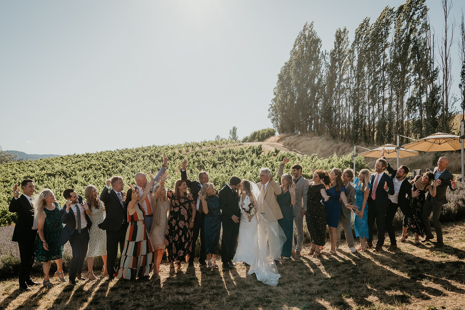 newlyweds kissing as their wedding guests cheer them on.