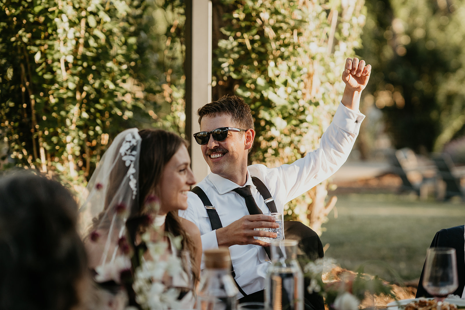 newlyweds cheering during their reception dinner.