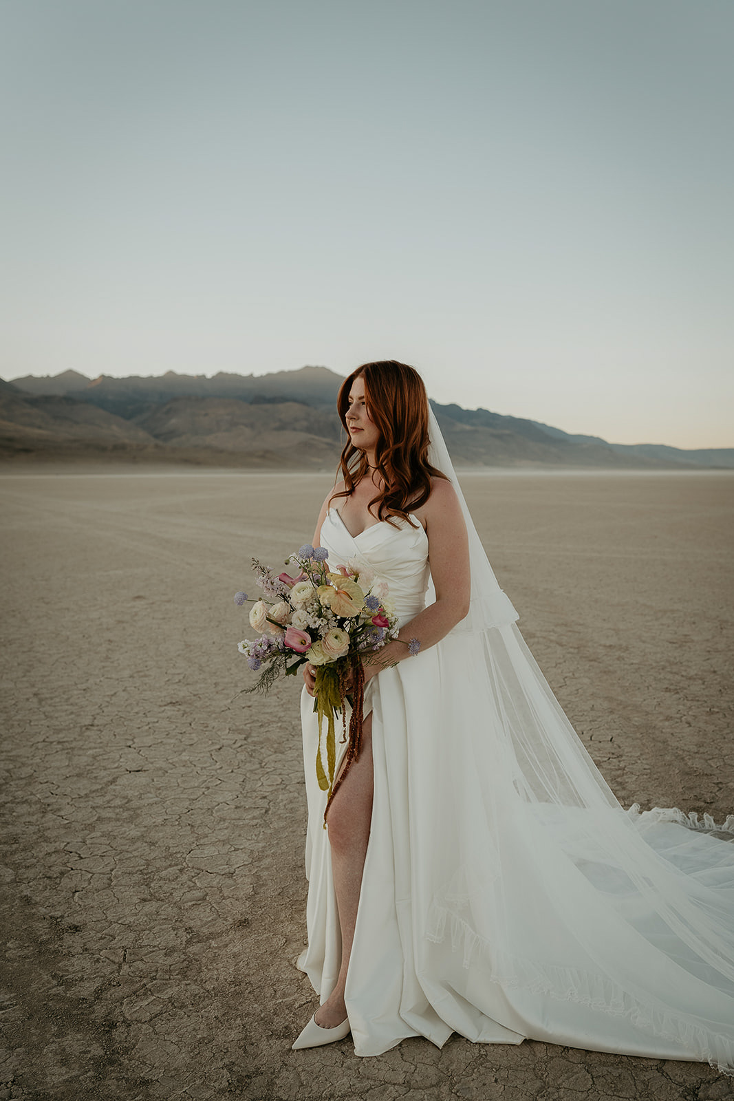 a bride standing in the Alvord Desert looking into the distance.