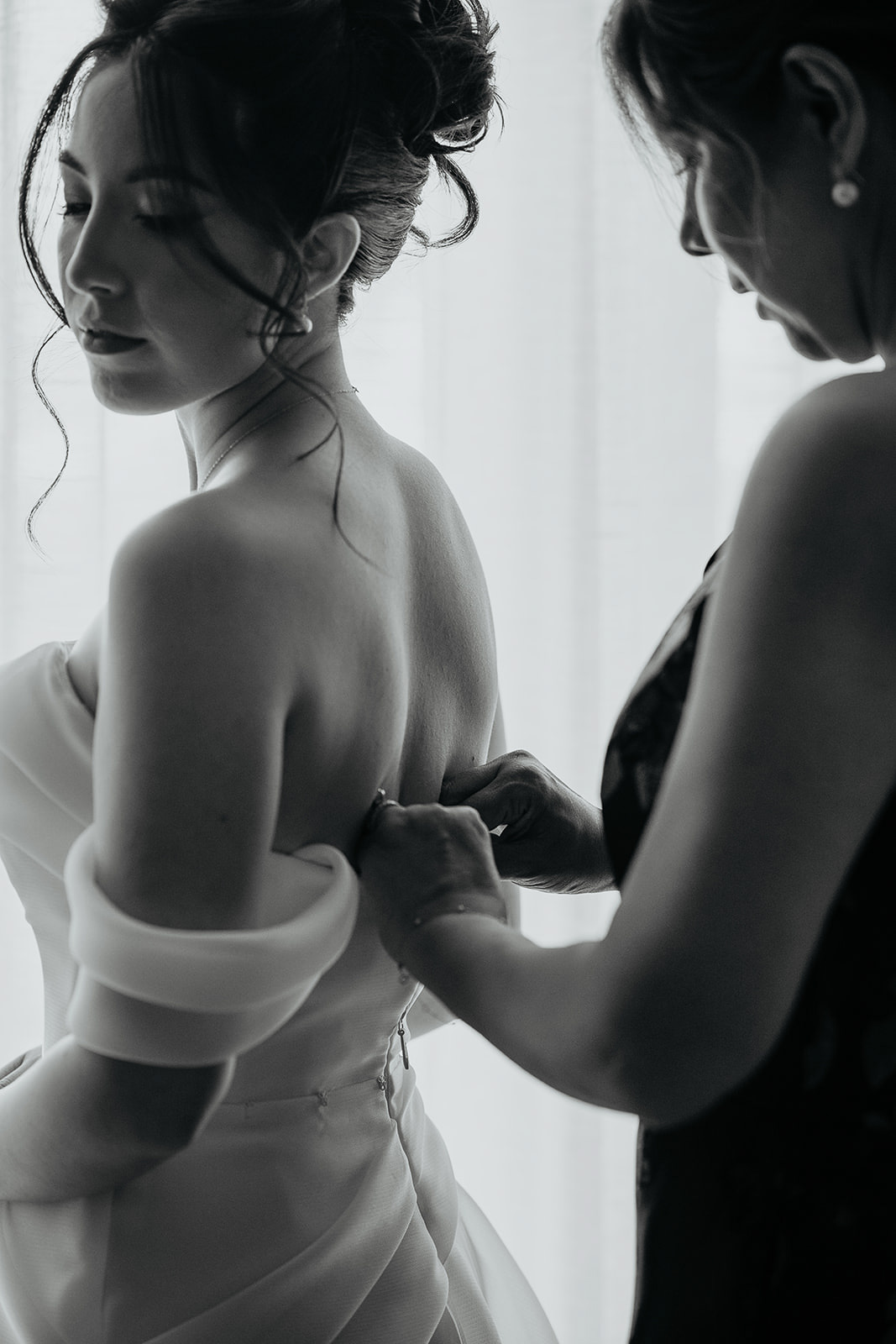 the bride's mom helping the bride zip up her dress during her Brasada Ranch wedding.