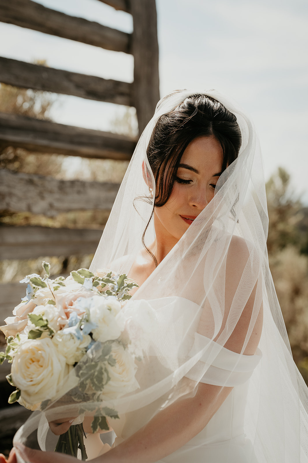 the bride looking down and away holding a bouquet of flowers.