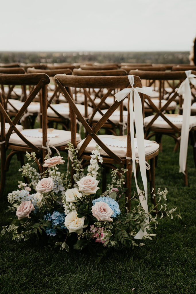 a bow wrapped onto a chair with a flower behind it in the Brasada Ranch wedding ceremony space.