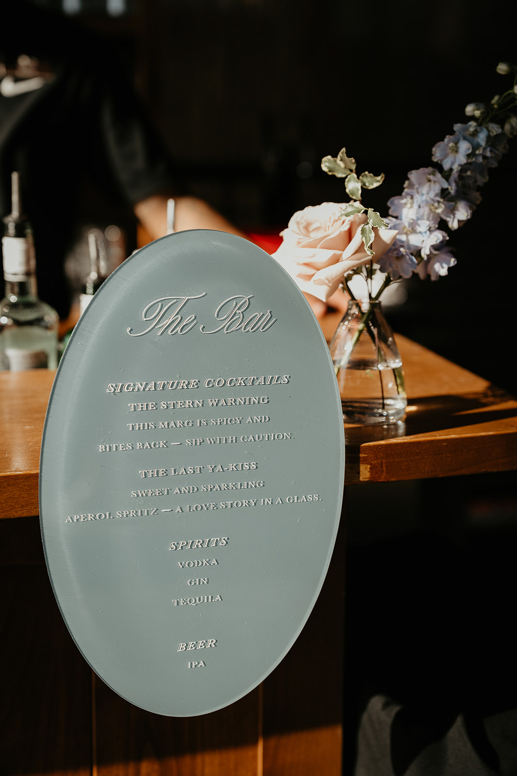 the bar menue with a vase of flowers behind it during a Brasada Ranch wedding.