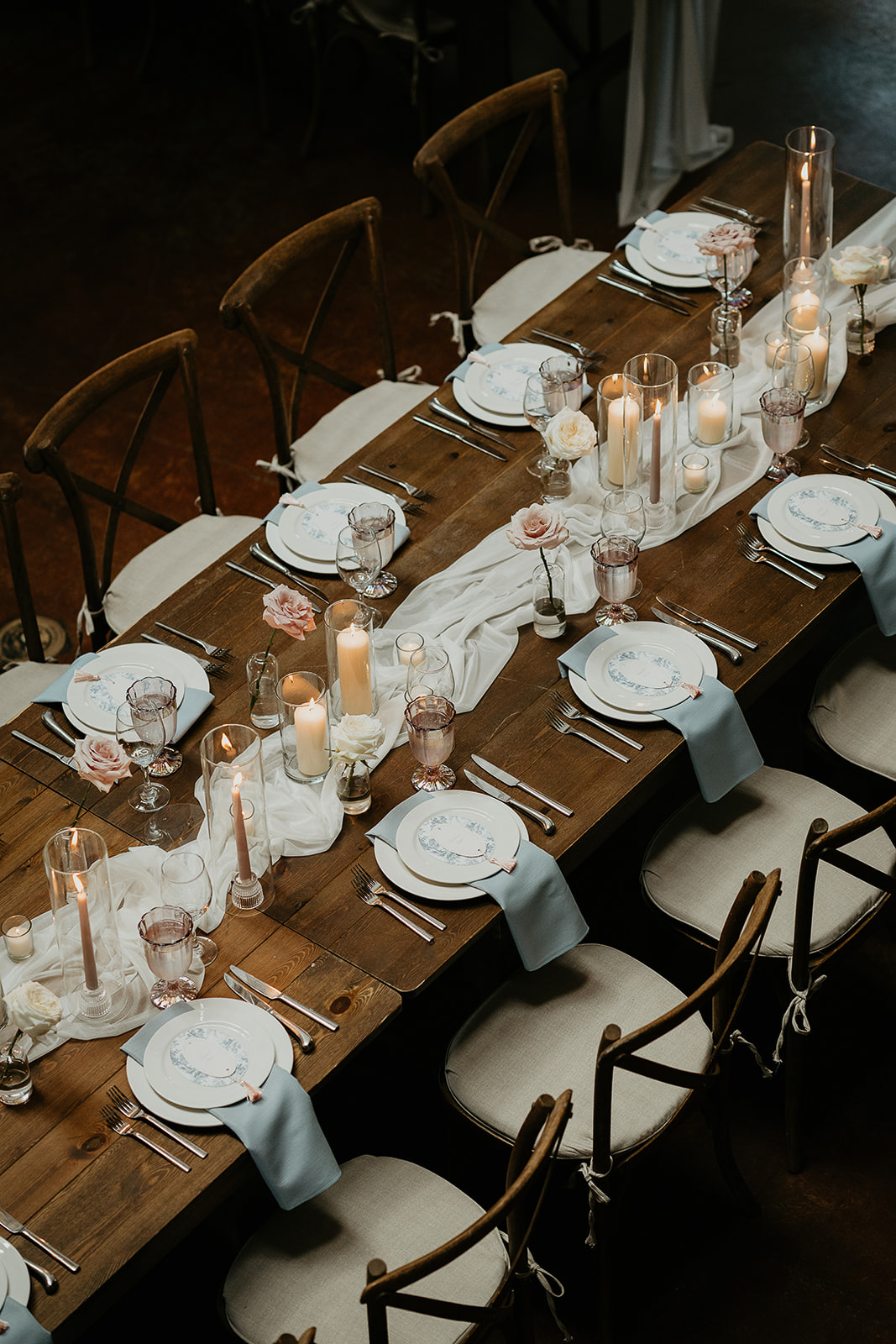 a table artfully decorated with classy table settings, a runner, and candles.