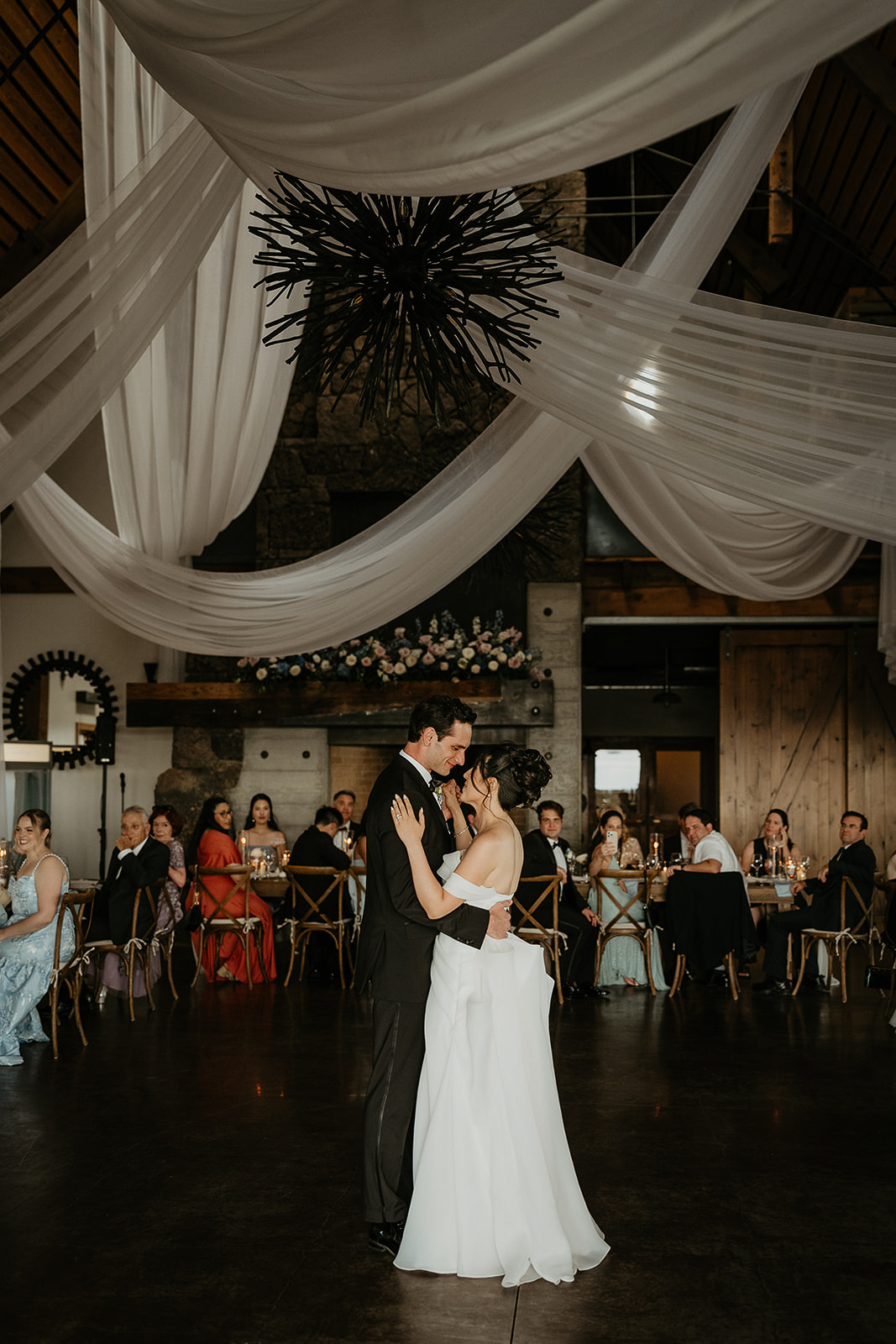 the newlyweds sharing a first dance inside the Barn during their Brasada Ranch wedding.