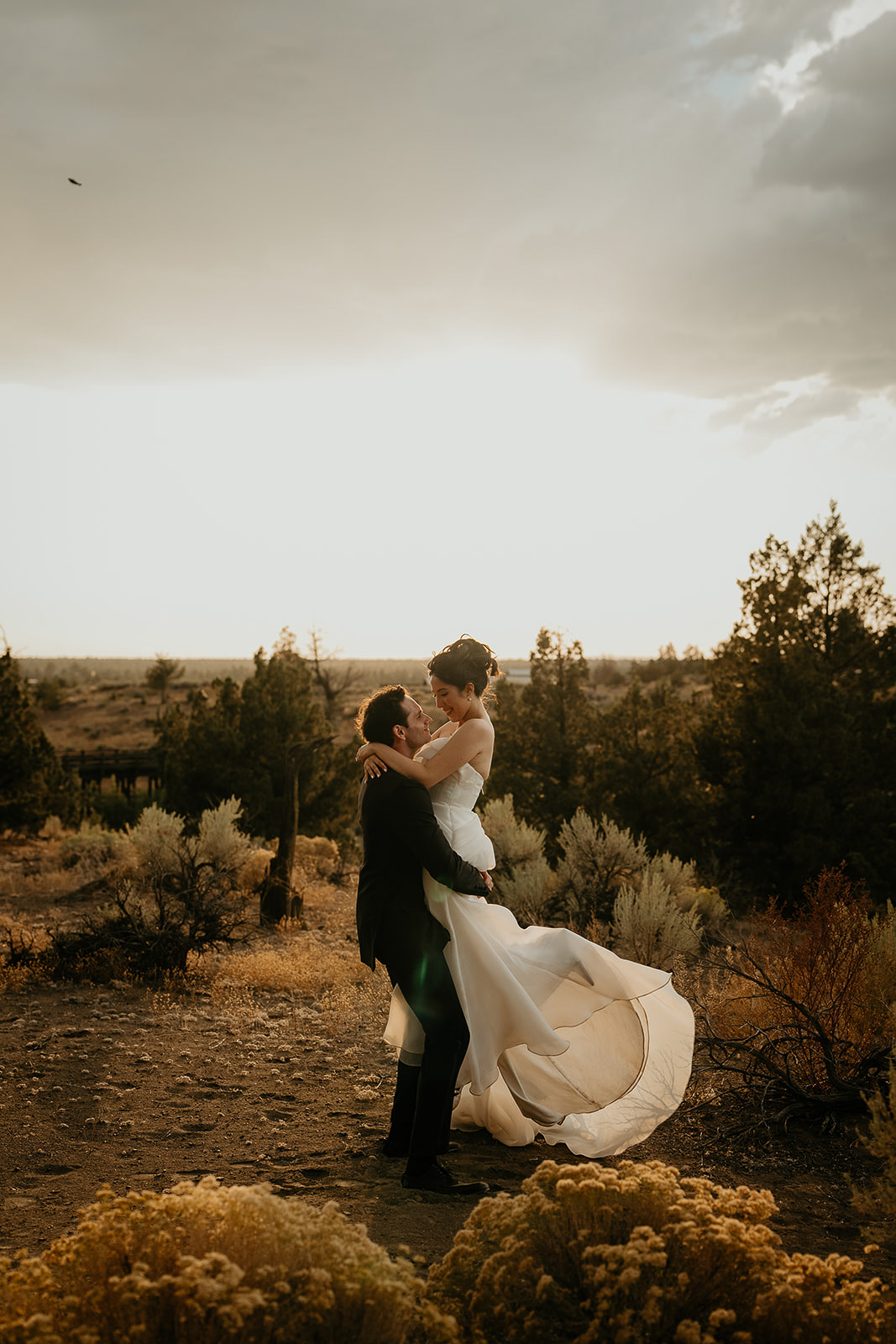 newlyweds dancing with the Oregon high desert around them at sunset during their Brasada Ranch wedding.