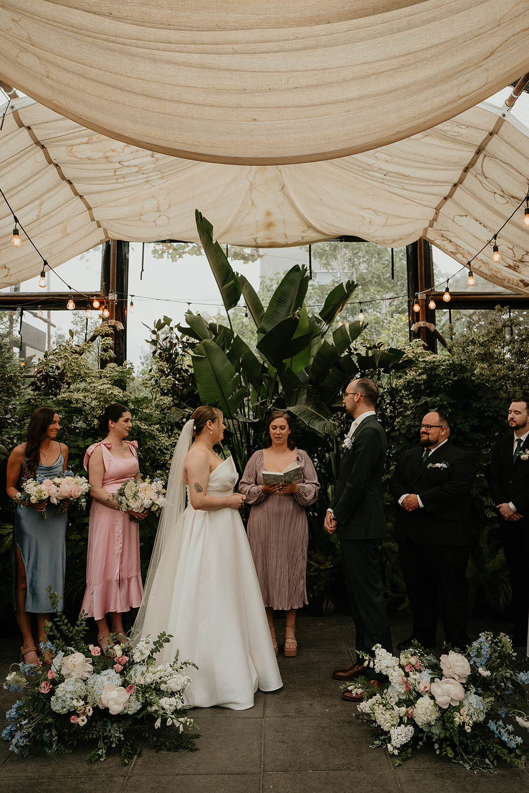 newlyweds holding their ceremony inside a greenhouse by the Blockhouse wedding venue.