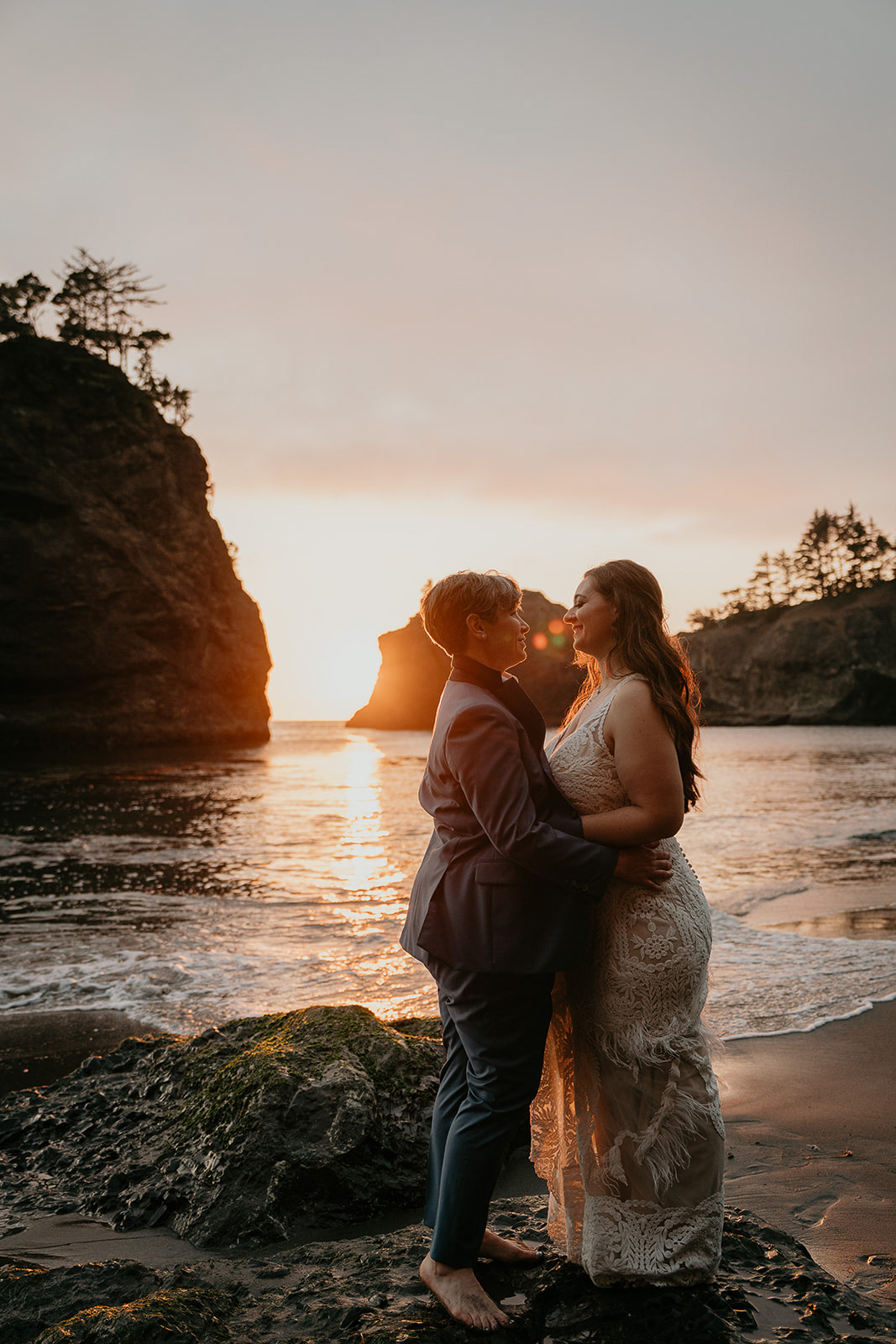 Newlyweds kissing at sunset along the Oregon Coast.