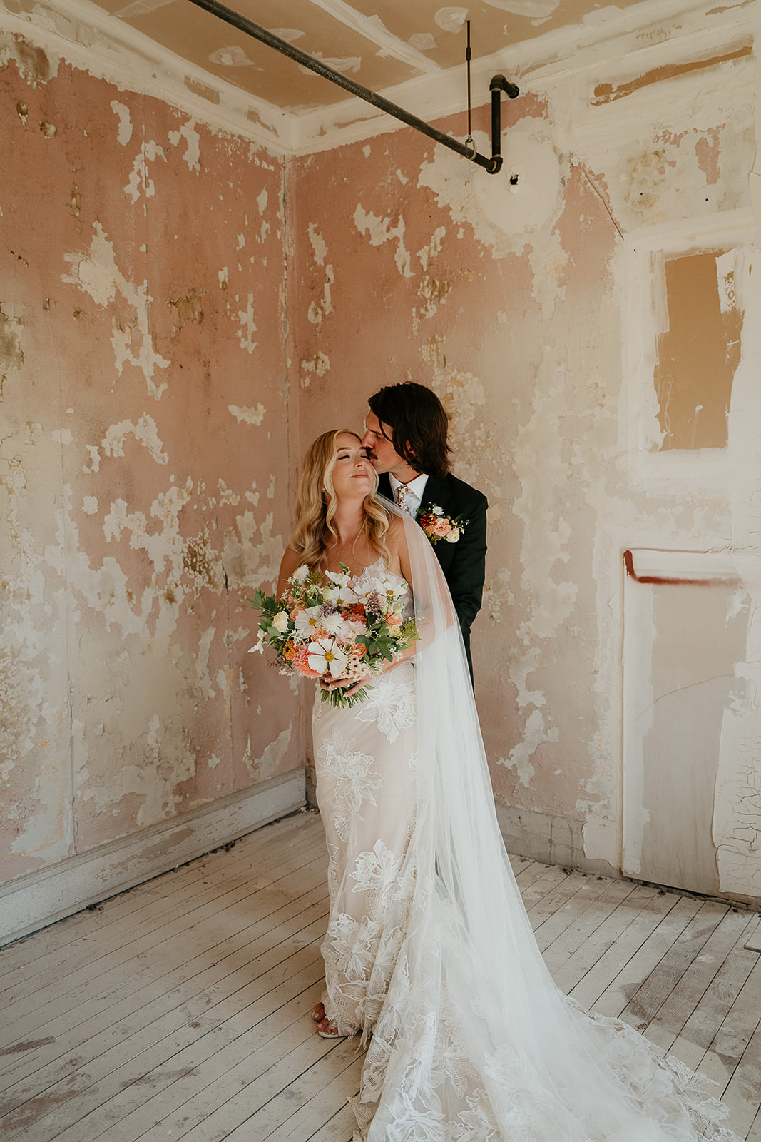 Newlyweds standing inside the Ruins at the Astor hugging.