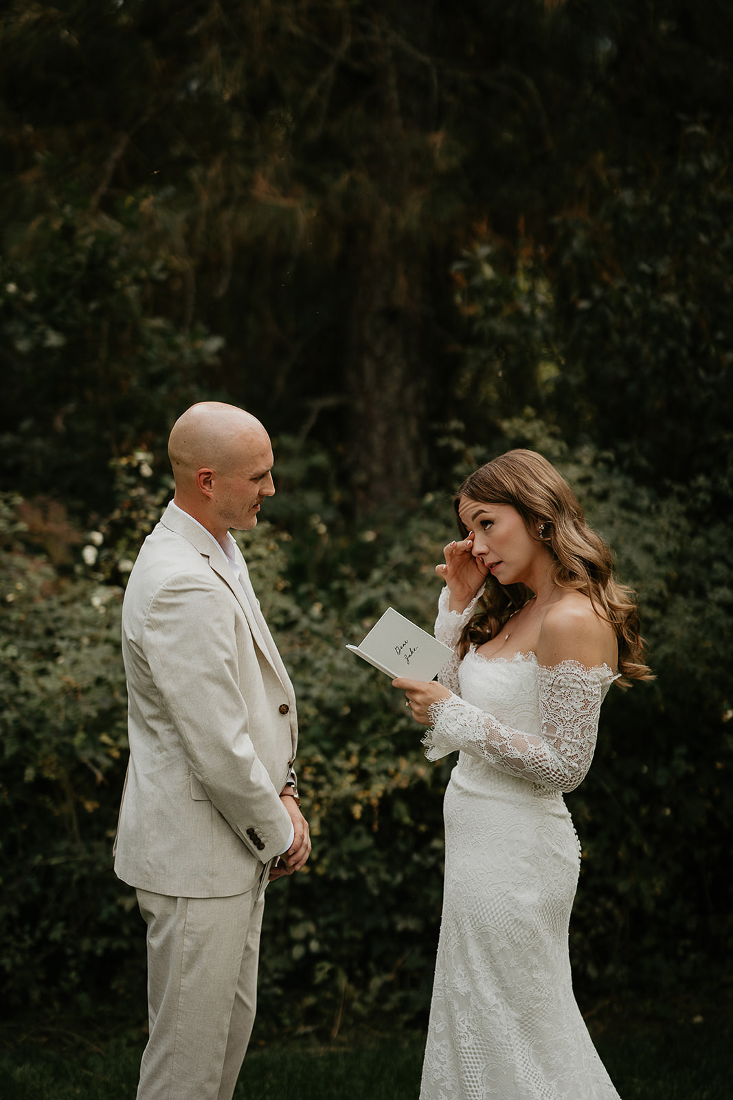 newlyweds sharing private vows in a forest.