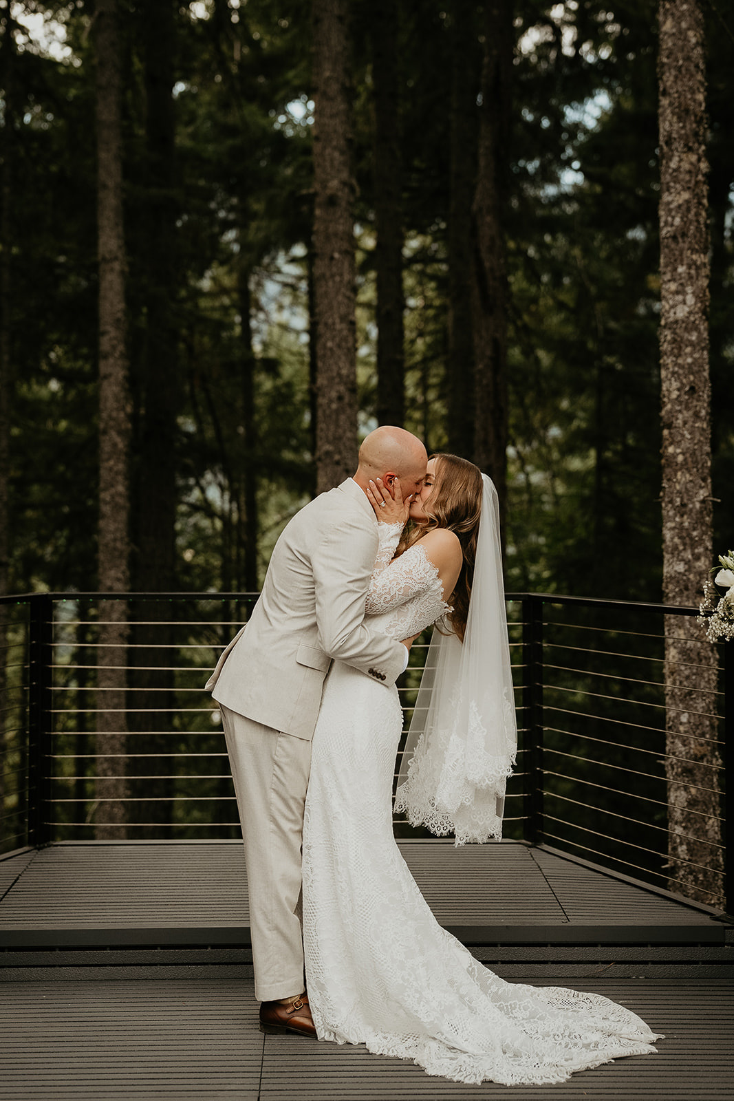 the newlyweds kissing with trees behind them during their Rocky Hill Oregon wedding.