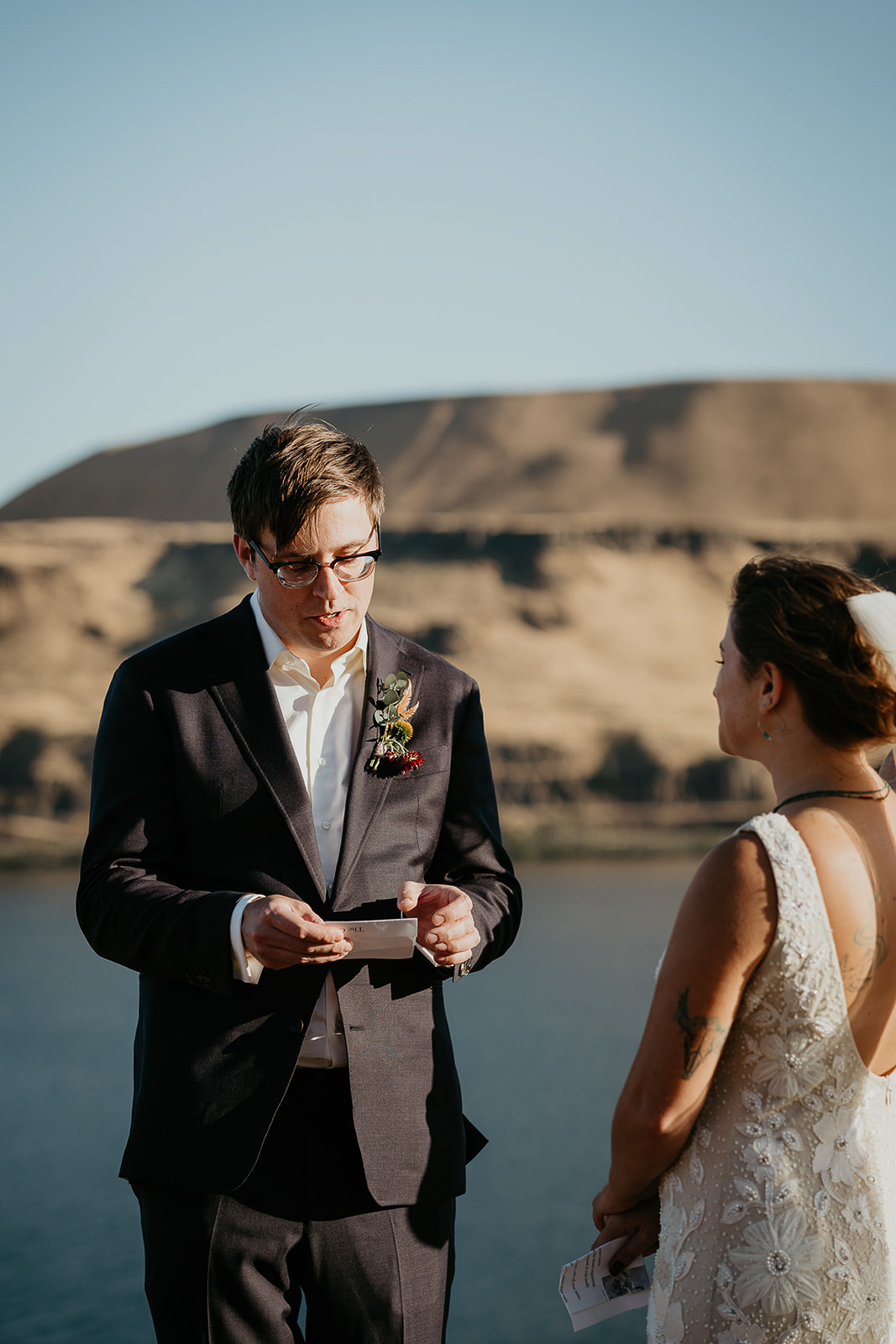 husband reading a poem to his bride with the columbia river in the background.