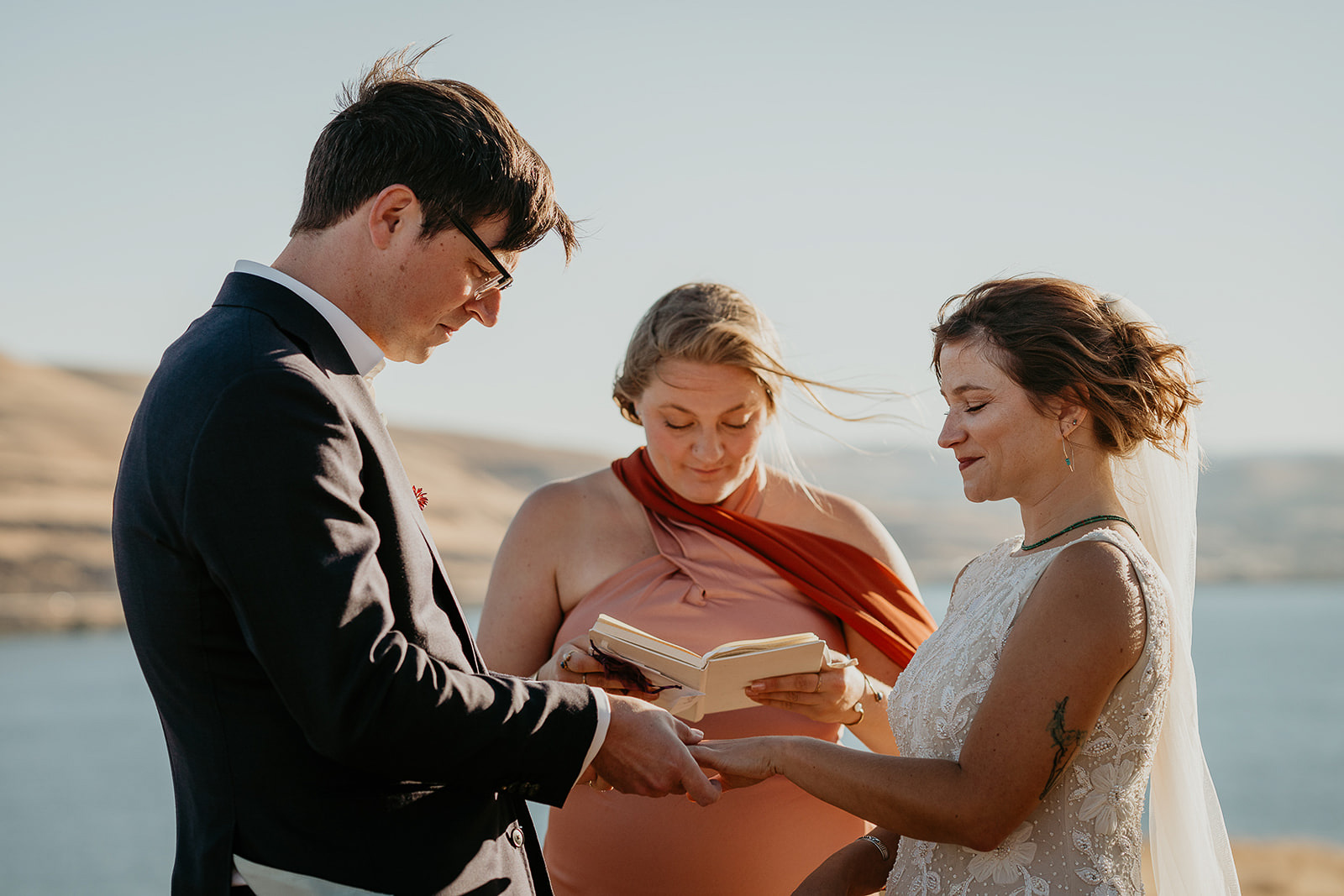 newlyweds holding hands during their ceremony in Columbia Hills State Historical Park.