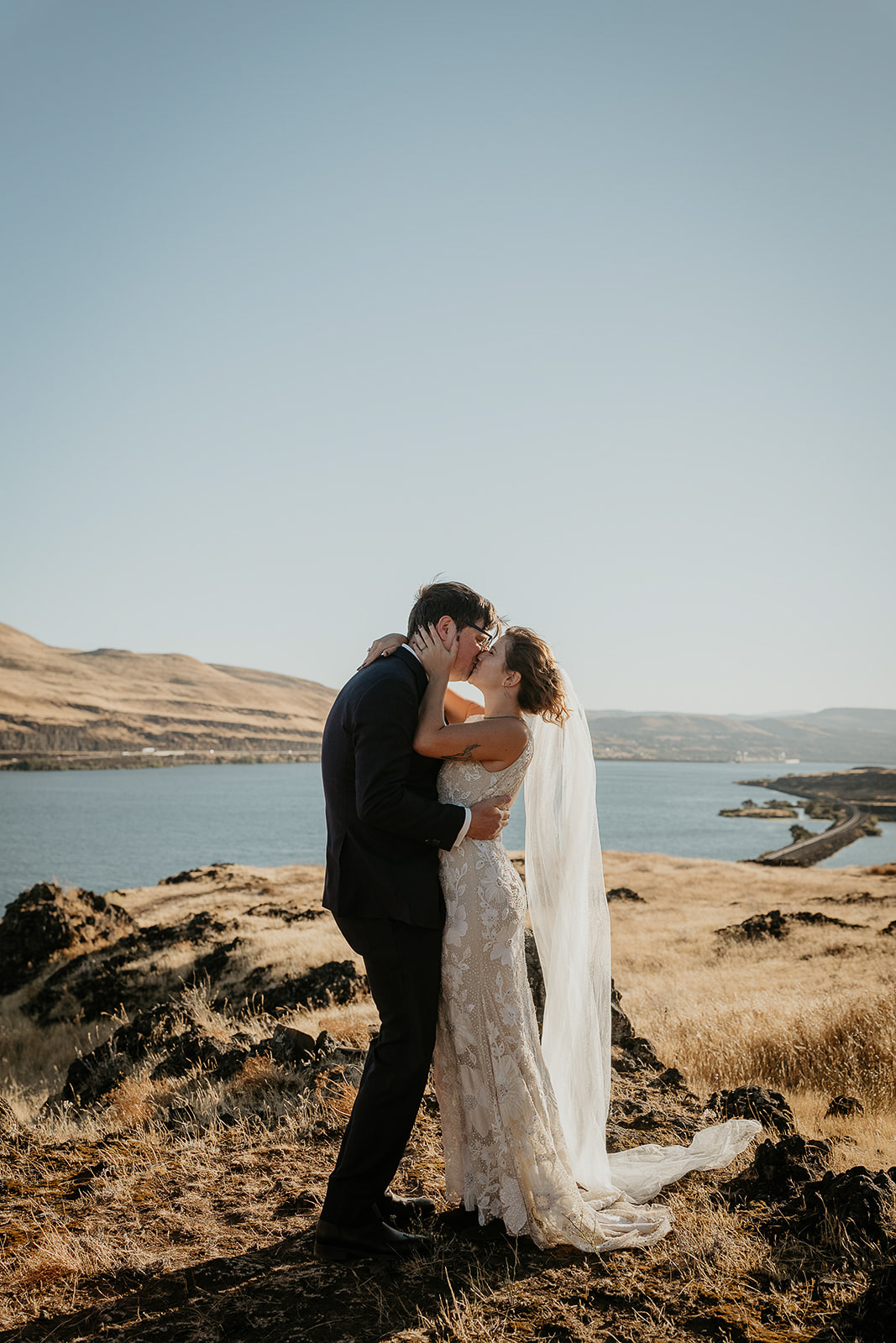 newlyweds kissing by the columbia river during their Columbia River Gorge elopement.