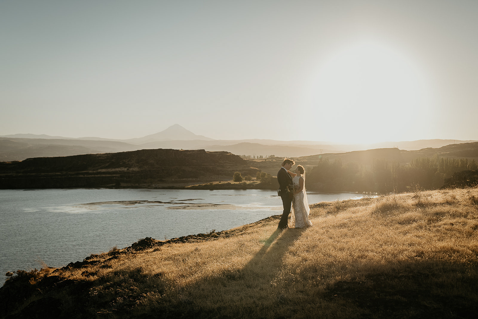 the newlyweds holding each other with the columbia river gorge in the background.