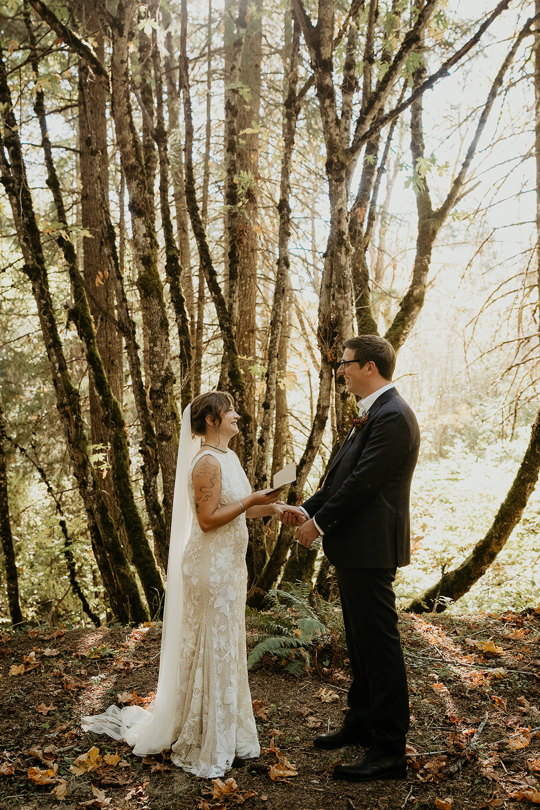 newlyweds holding hands exchanging private vows in a forest during their Columbia River Gorge elopement.
