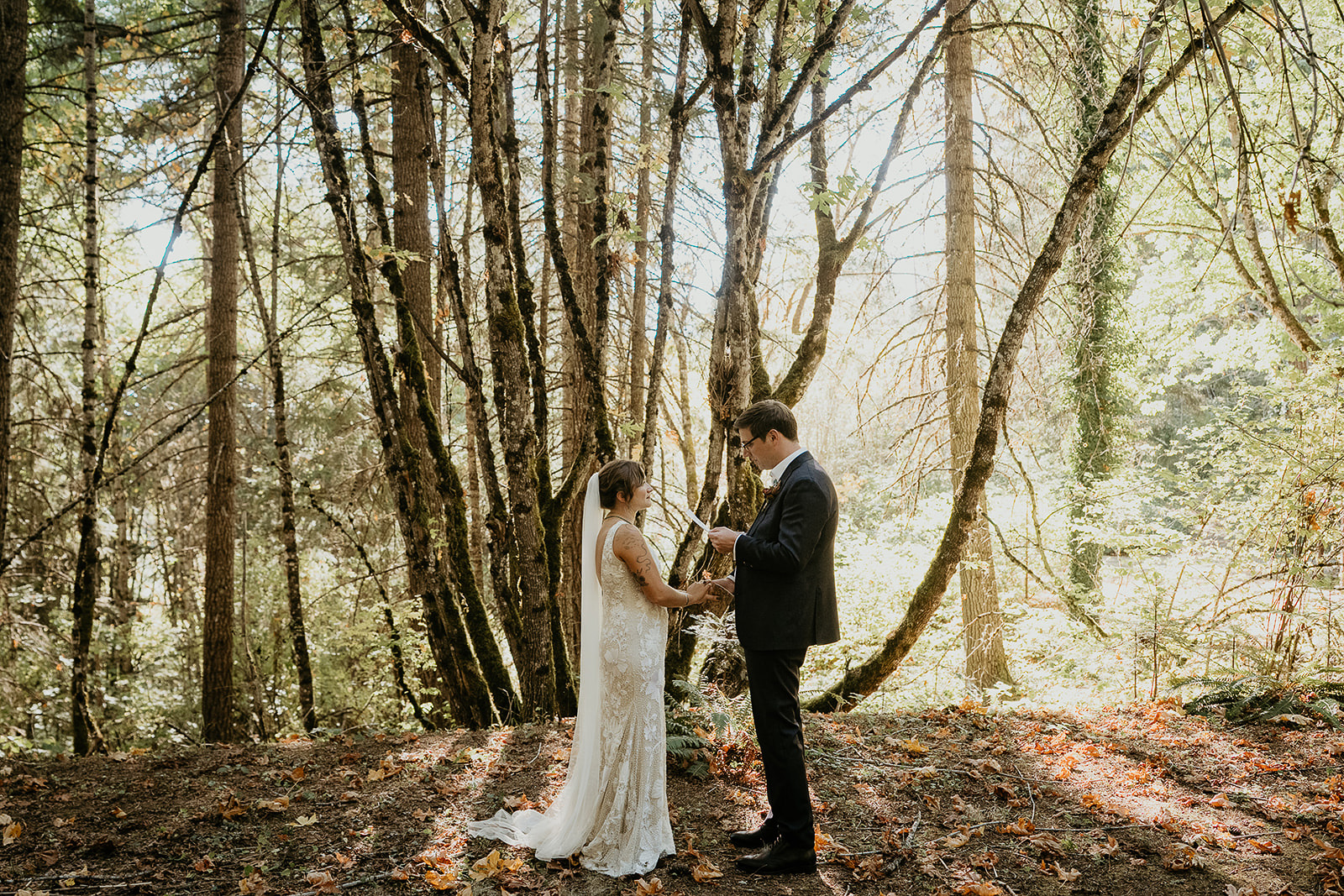 newlyweds holding hands and reading letters during their Columbia River Gorge elopement.