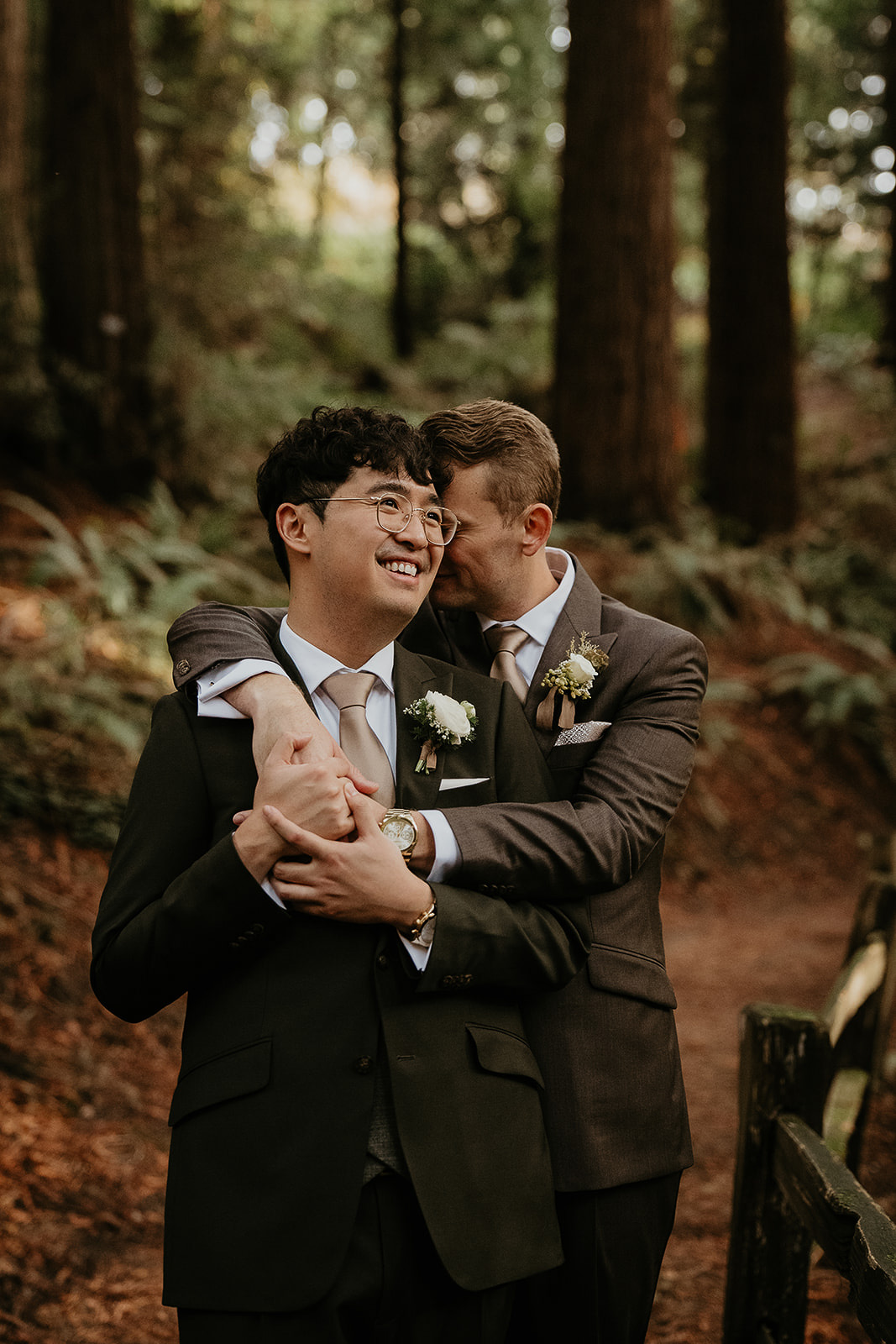 newlyweds hugging on a forest trail