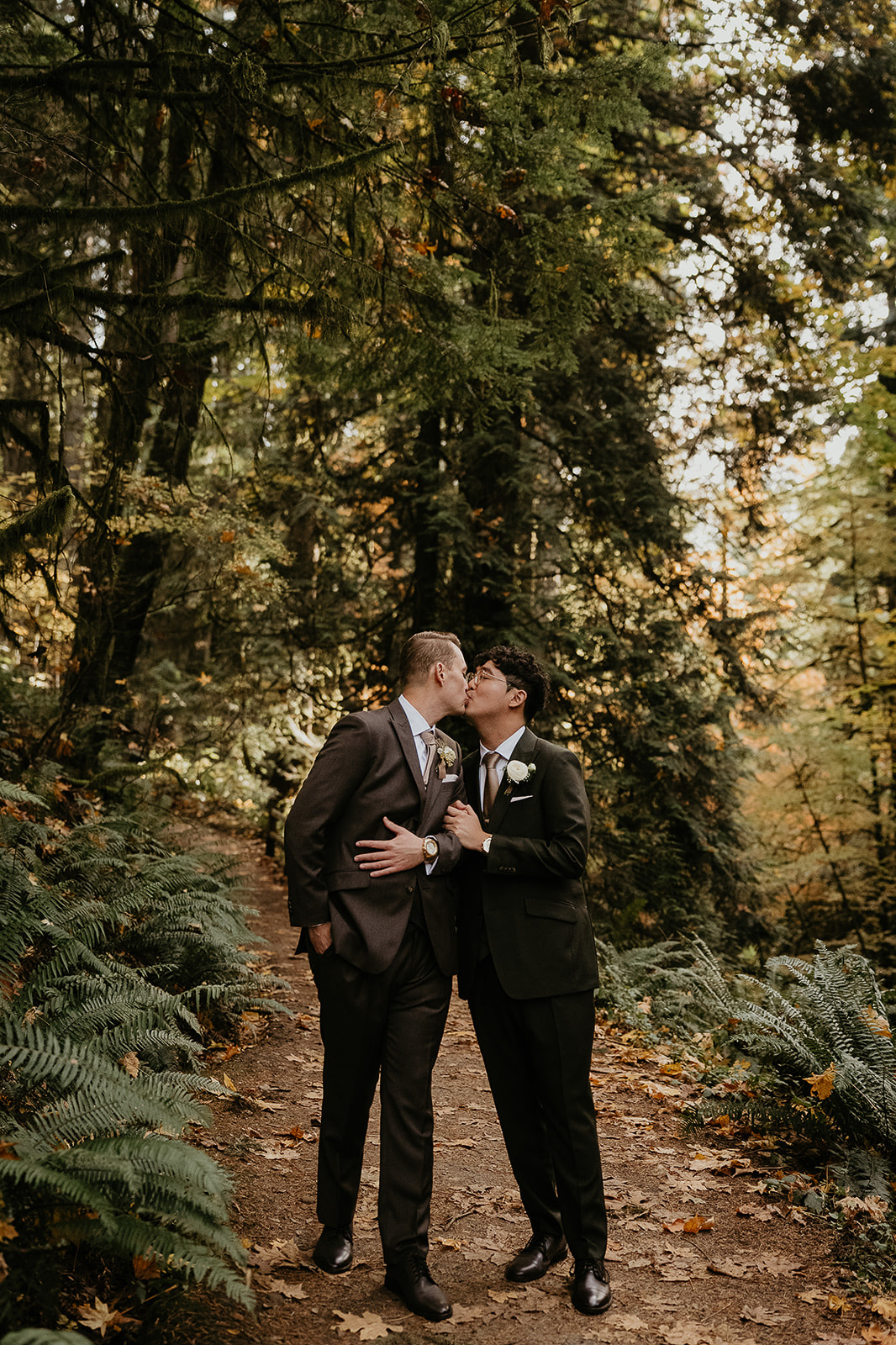 newlyweds kissing on a forest trail during their forest elopement in Oregon.