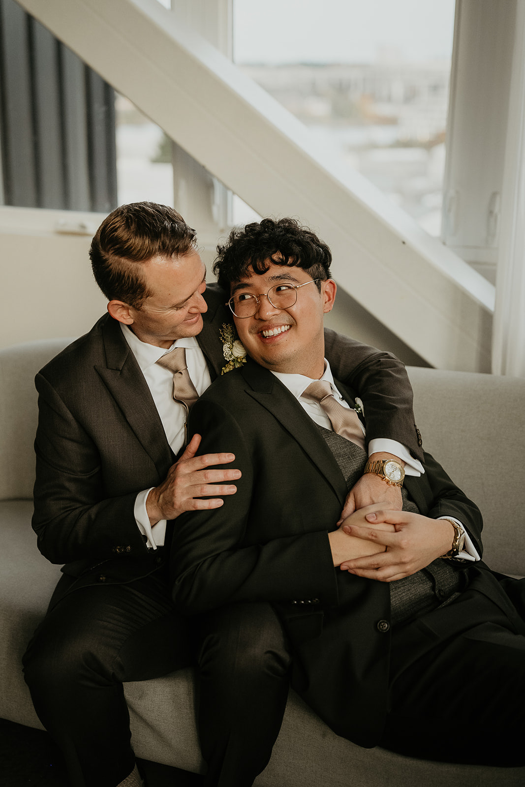 newlyweds hugging on a couch during their forest elopement in Oregon.