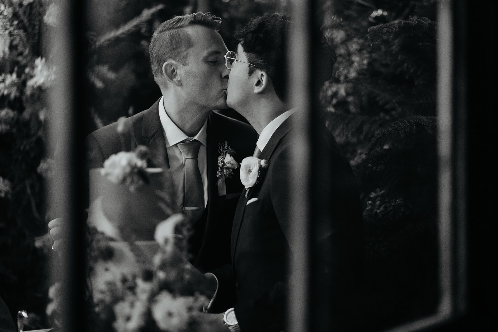 newlyweds kissing while cutting their cake during their forest elopement in Oregon.