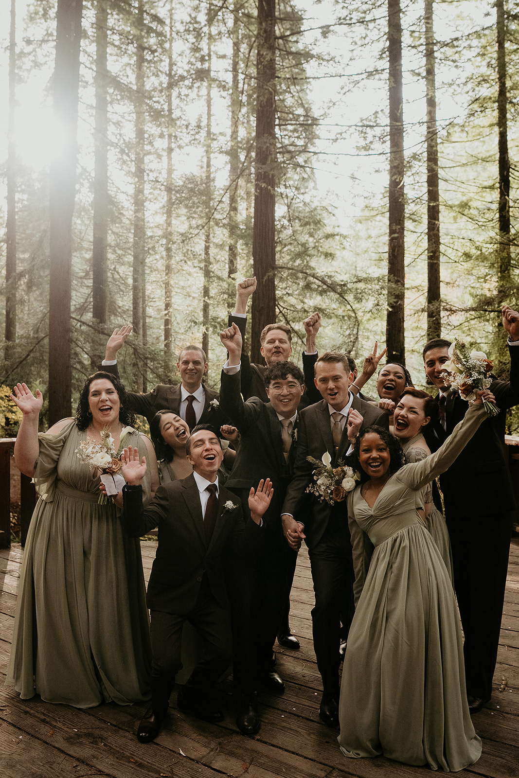 newlyweds cheering with their wedding party during their forest elopement in Oregon.