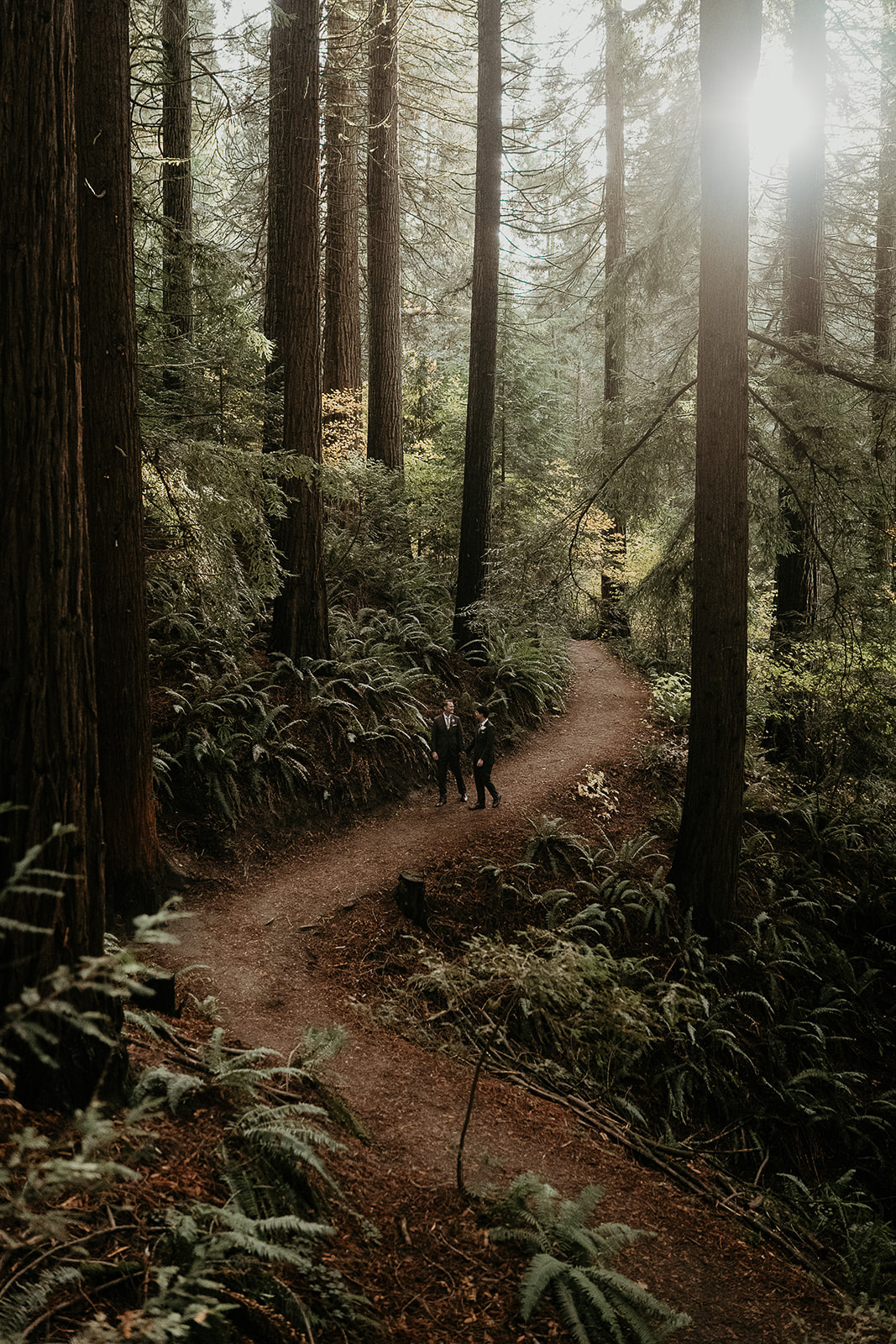 newlyweds walking along a trail during their forest elopement in Oregon.