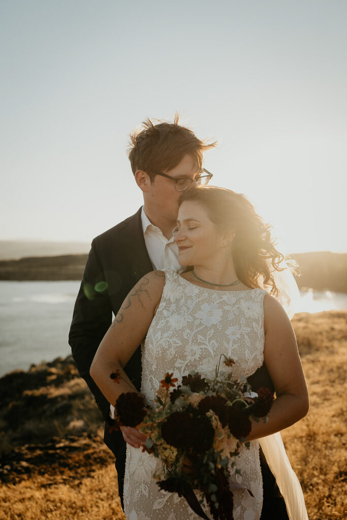 newlyweds hugging at sunset during their columbia river gorge elopement.