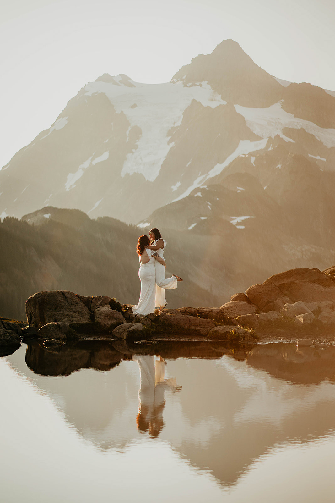newlyweds hugging at in the mountains as they elope at sunrise.