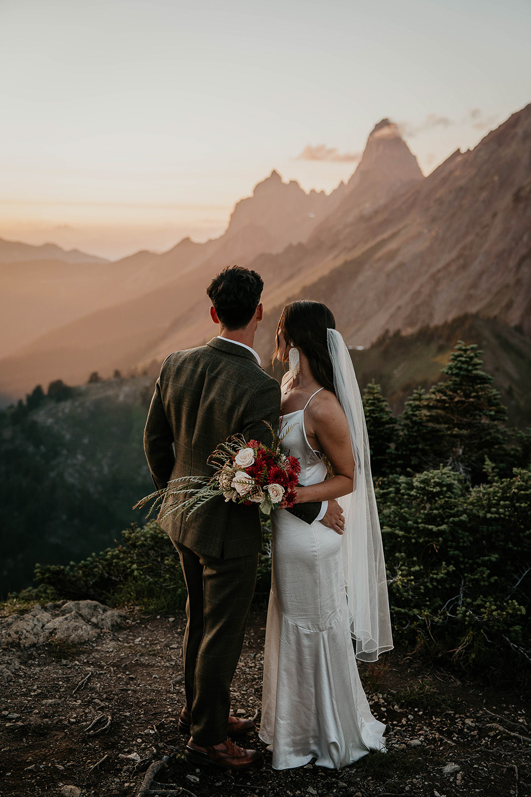 newlyweds enjoying the views of the mountains as they elope at sunset.