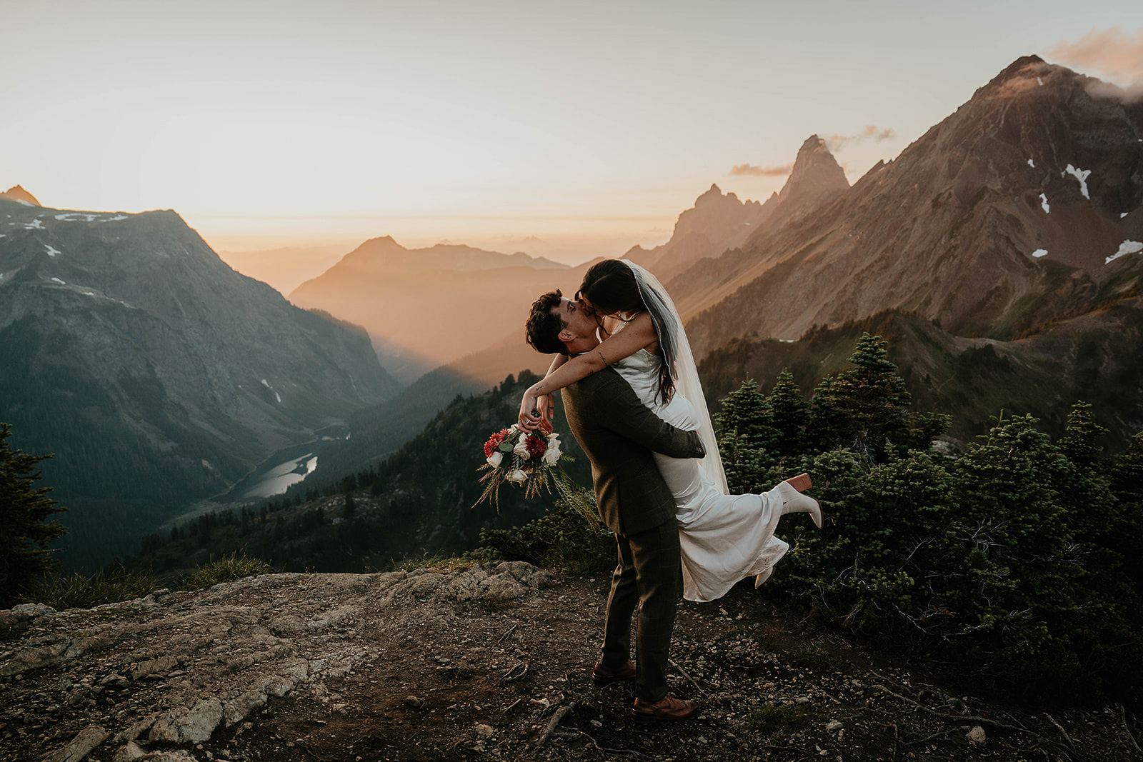 newlyweds kissing in the mountains as they elope at sunset.